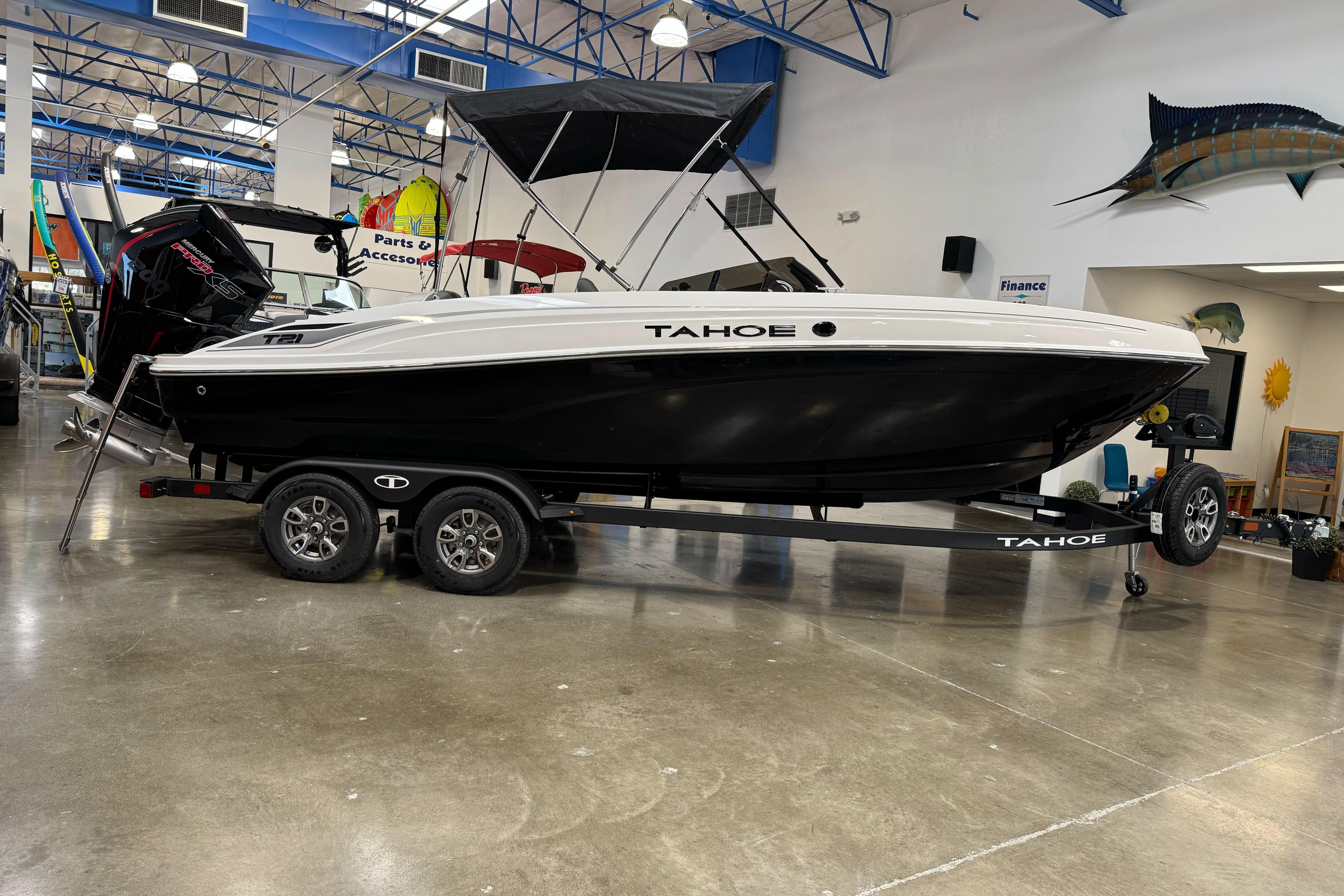 2026 Tahoe T21 boat on trailer in showroom, black and white design.