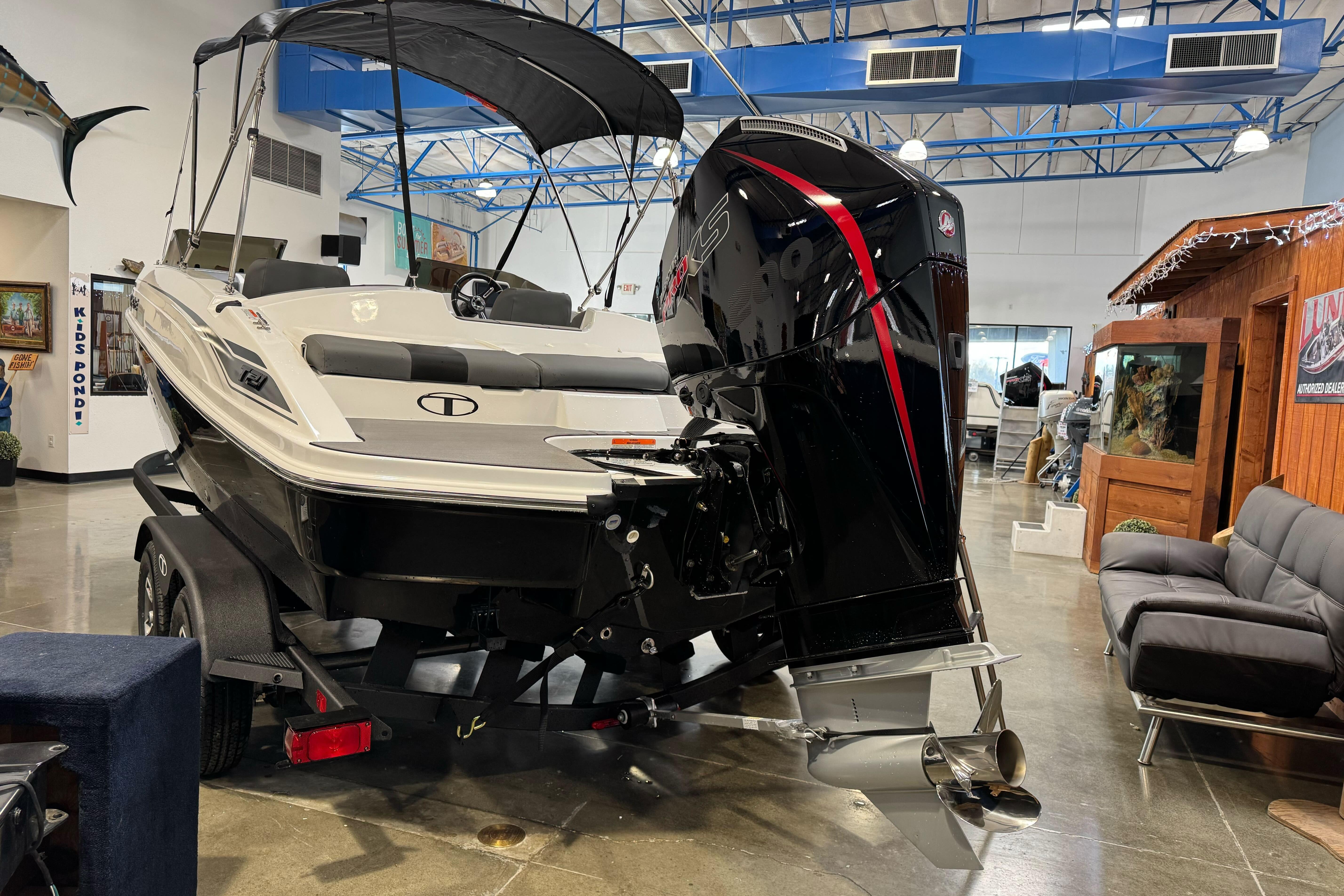 2026 Tahoe T21 boat with outboard motor displayed in showroom.