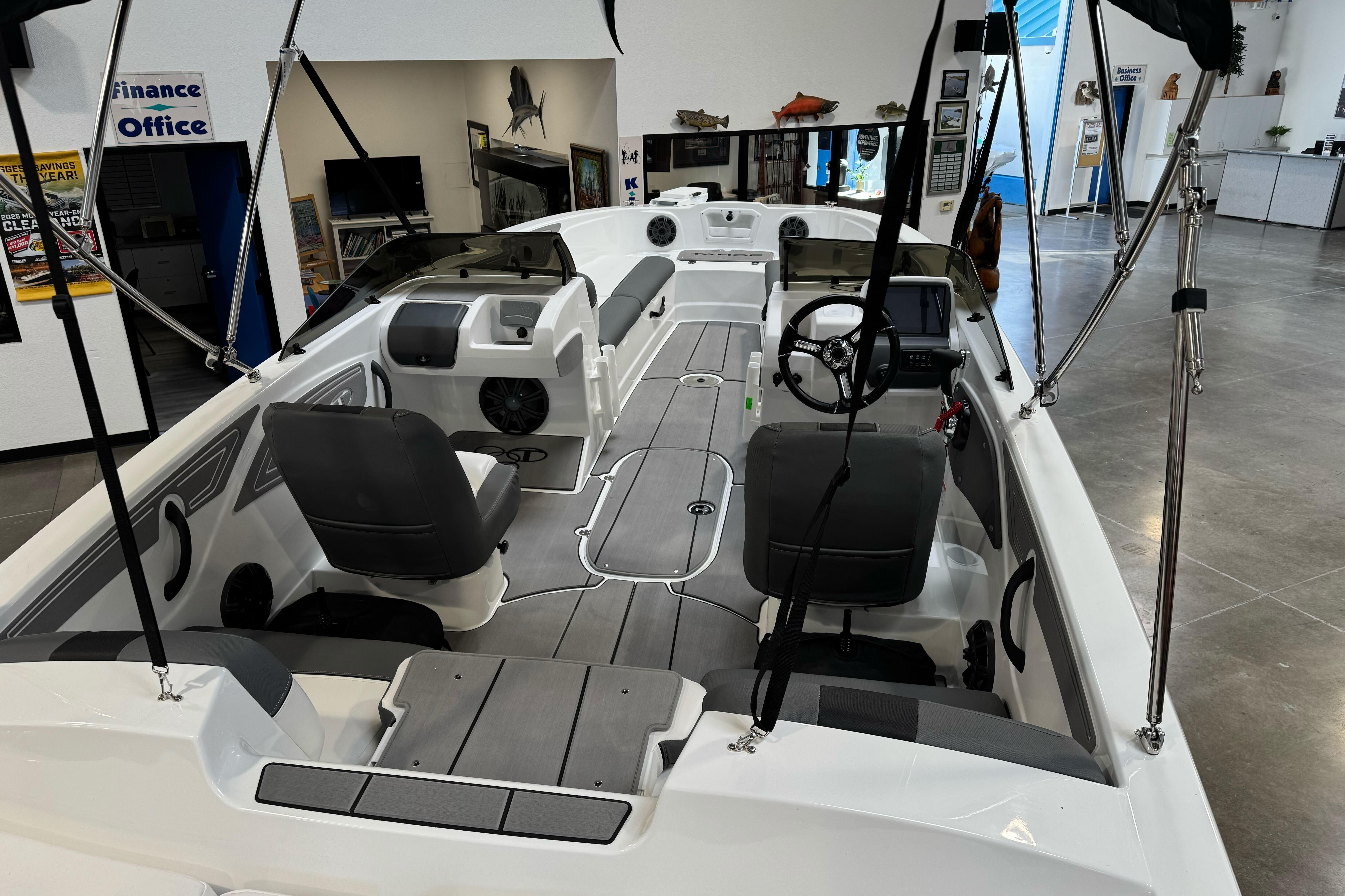 2026 Tahoe T21 boat interior with modern seating and steering, displayed in showroom.