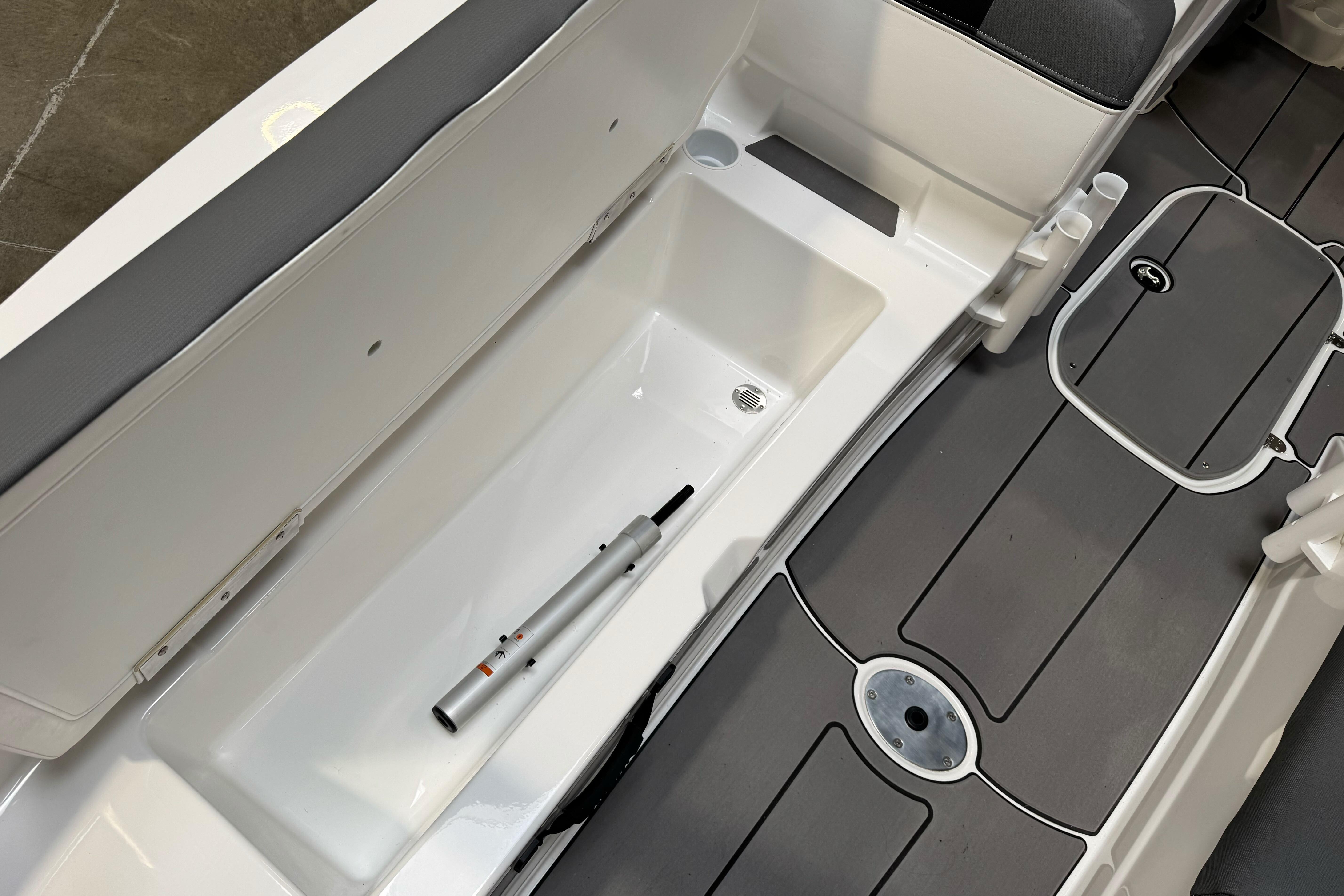 2026 Tahoe T21 boat interior with storage compartment and sleek gray flooring.