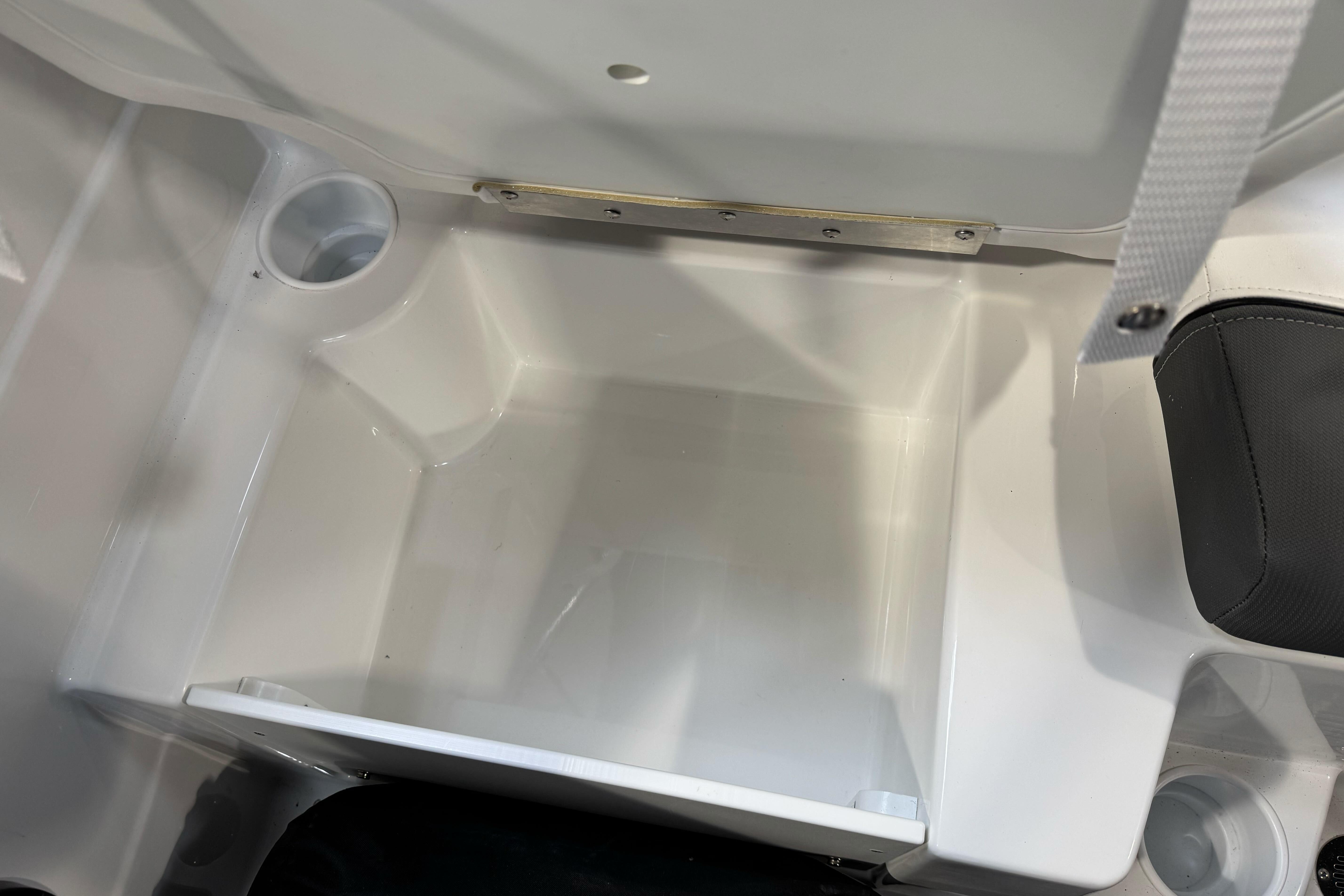 2026 Tahoe T21 boat storage compartment with cup holders and cushioned seating.