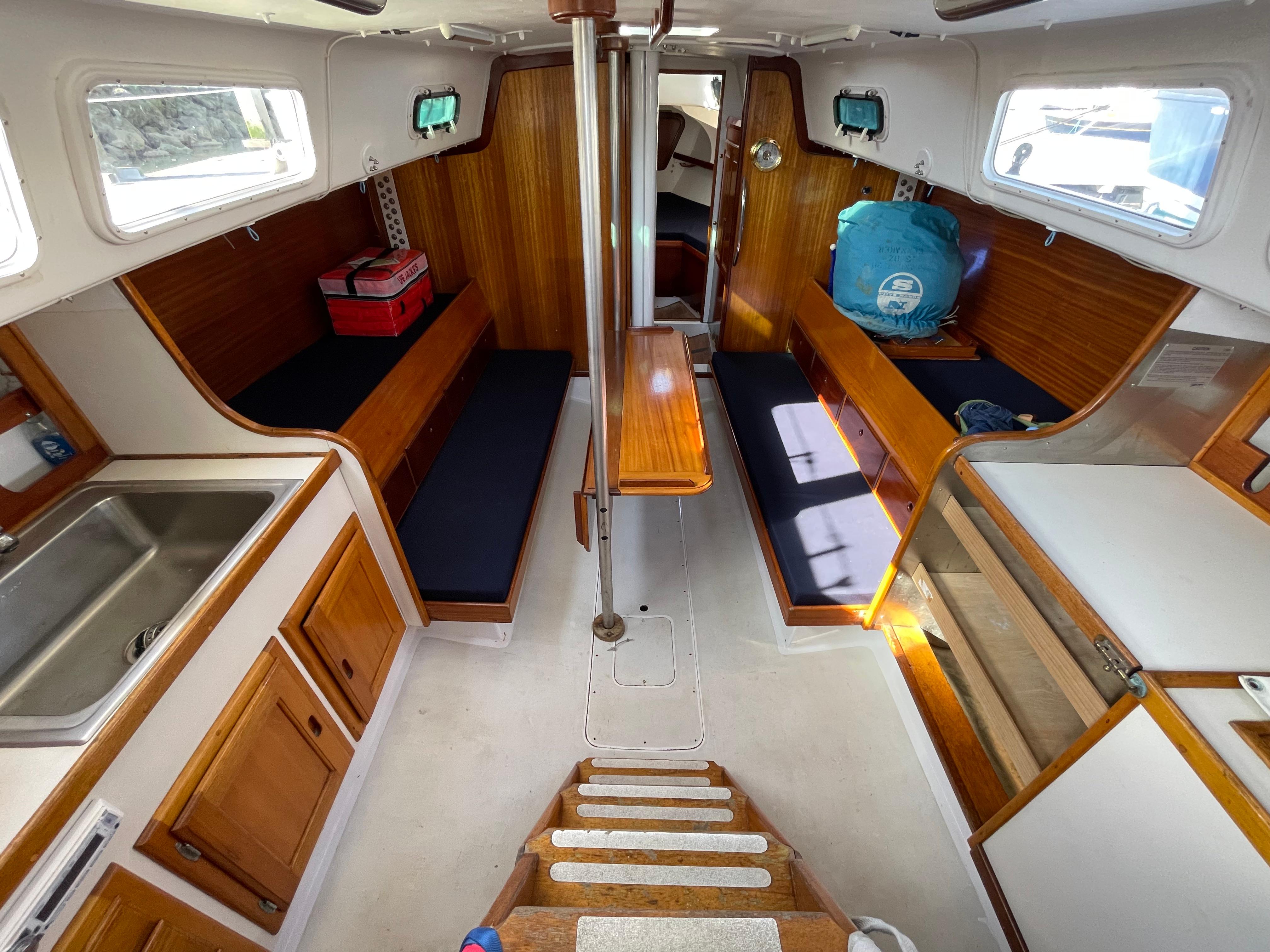 Interior of a 1964 CAL 40 sailboat with wooden cabinetry and seating.