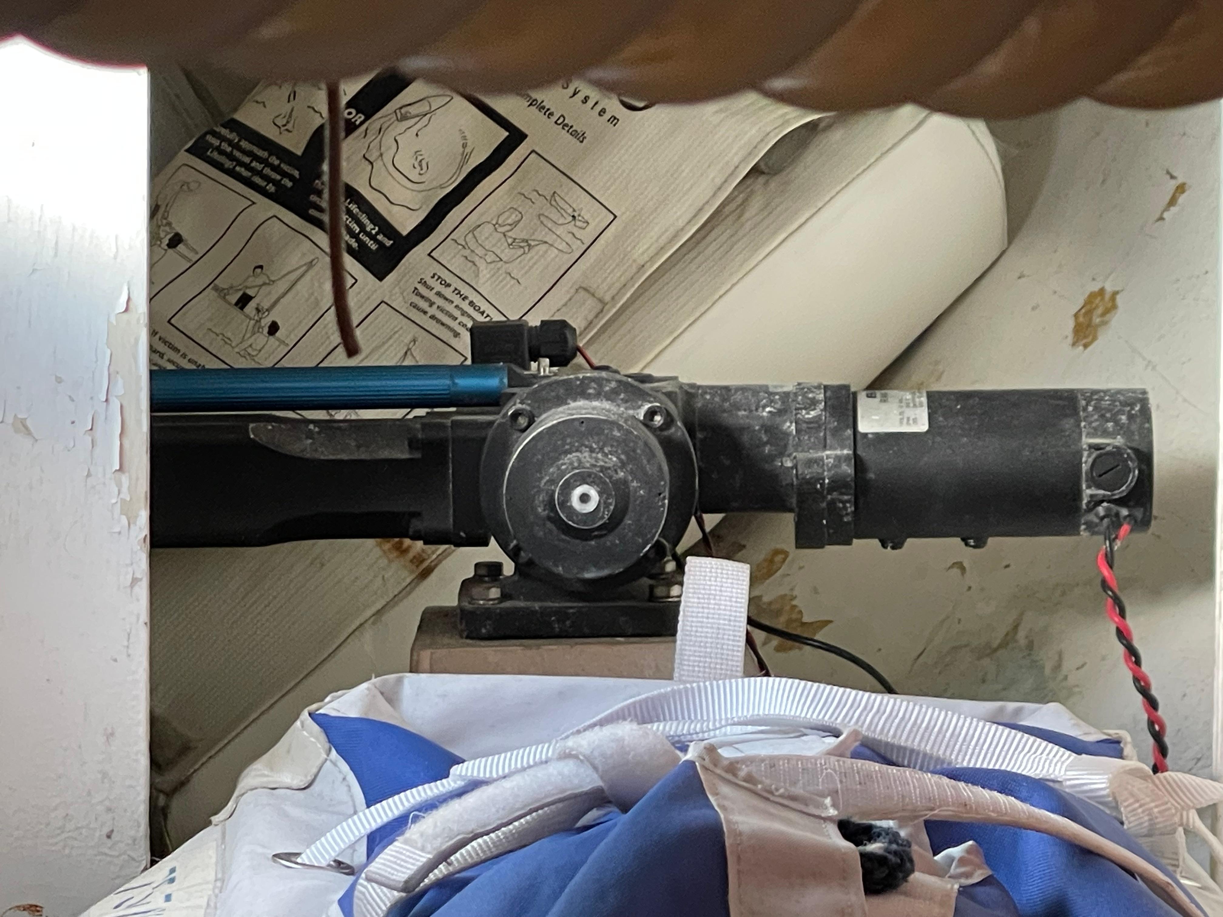 Motor mechanism inside a CAL 40 sailboat from 1964, with instructional diagrams in the background.