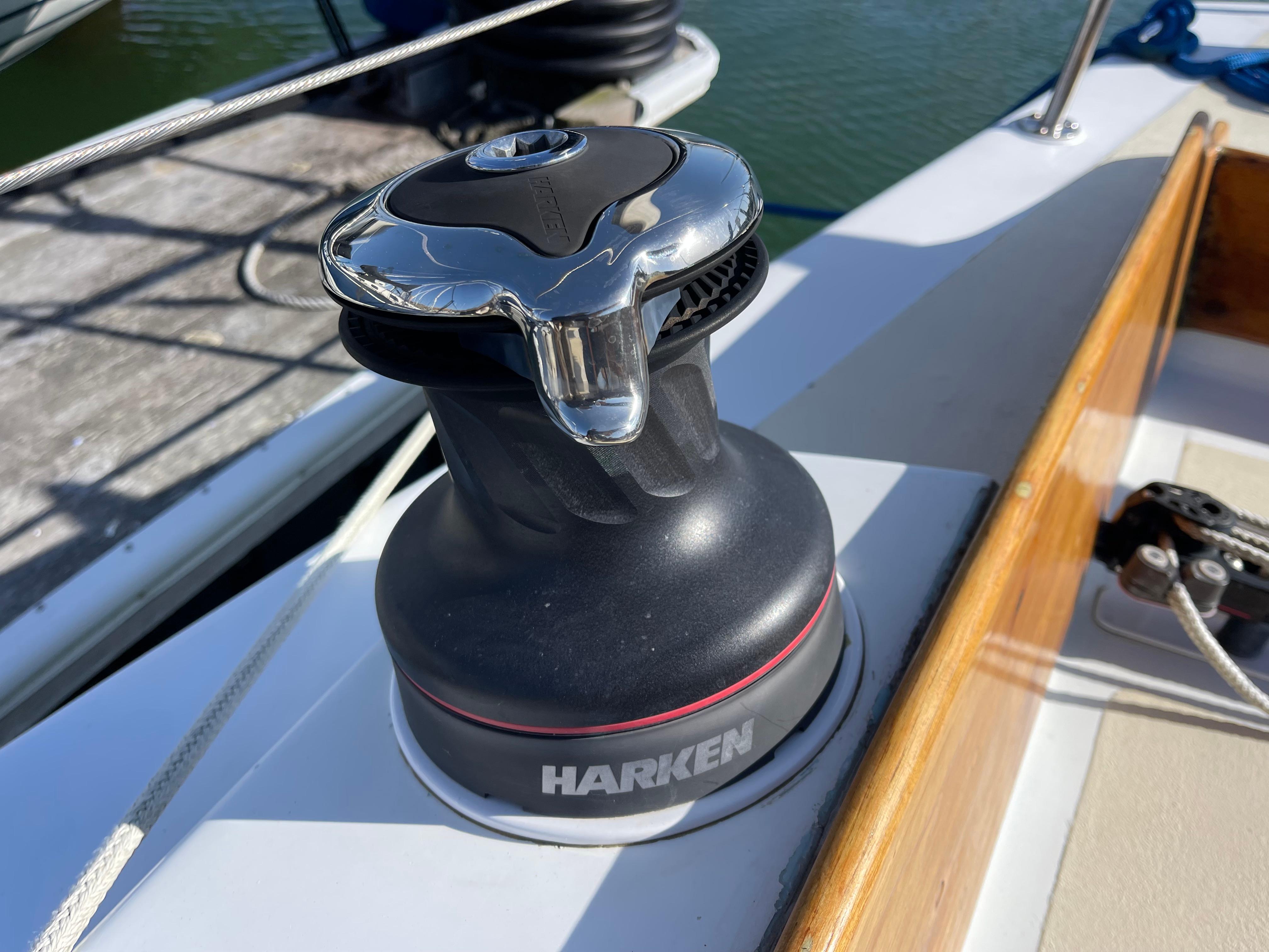 Harken winch on a 1964 CAL 40 sailboat deck, with ropes and wooden trim.