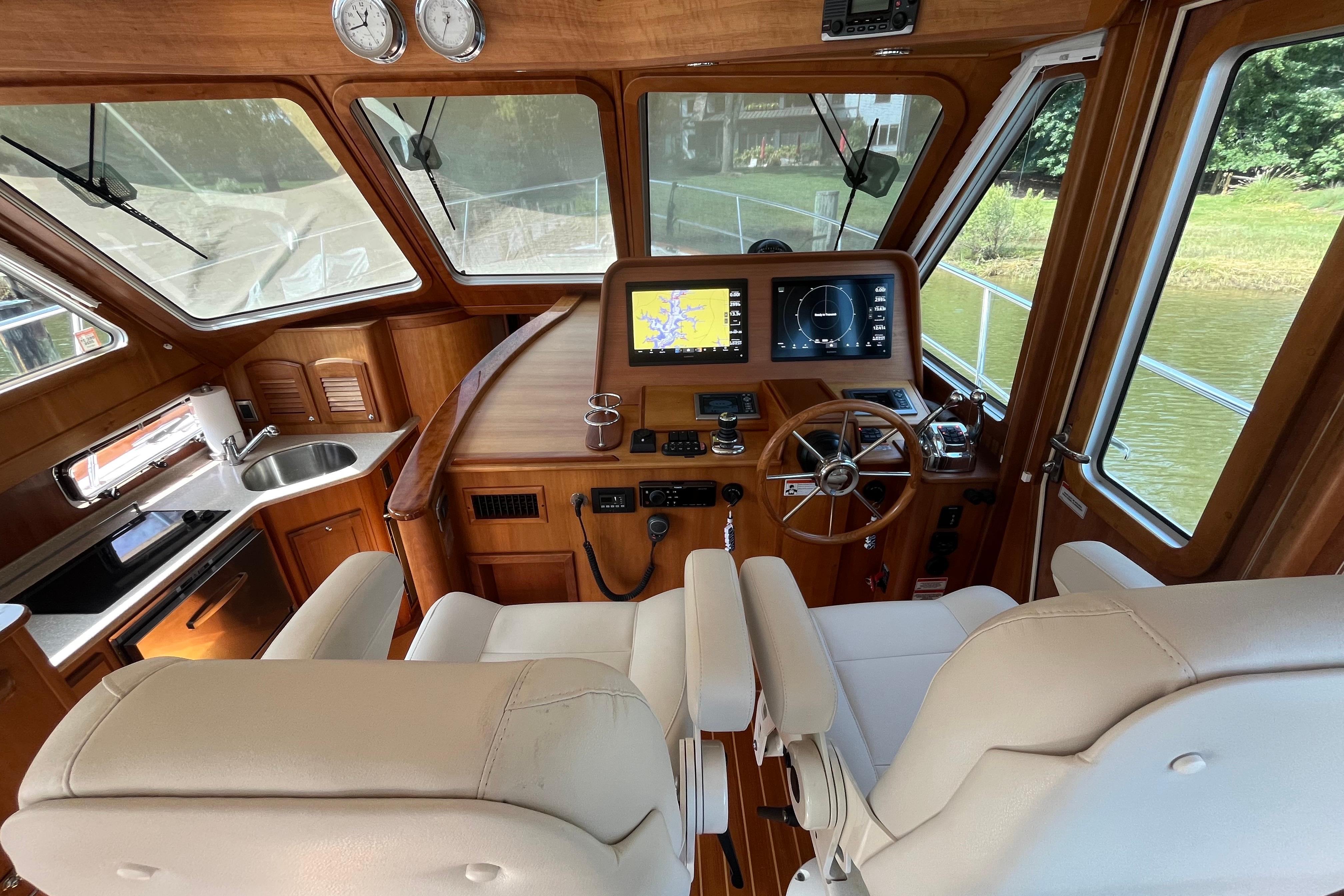 Interior of 2012 Sabre 42 Salon Express yacht with helm, navigation screens, and kitchenette.