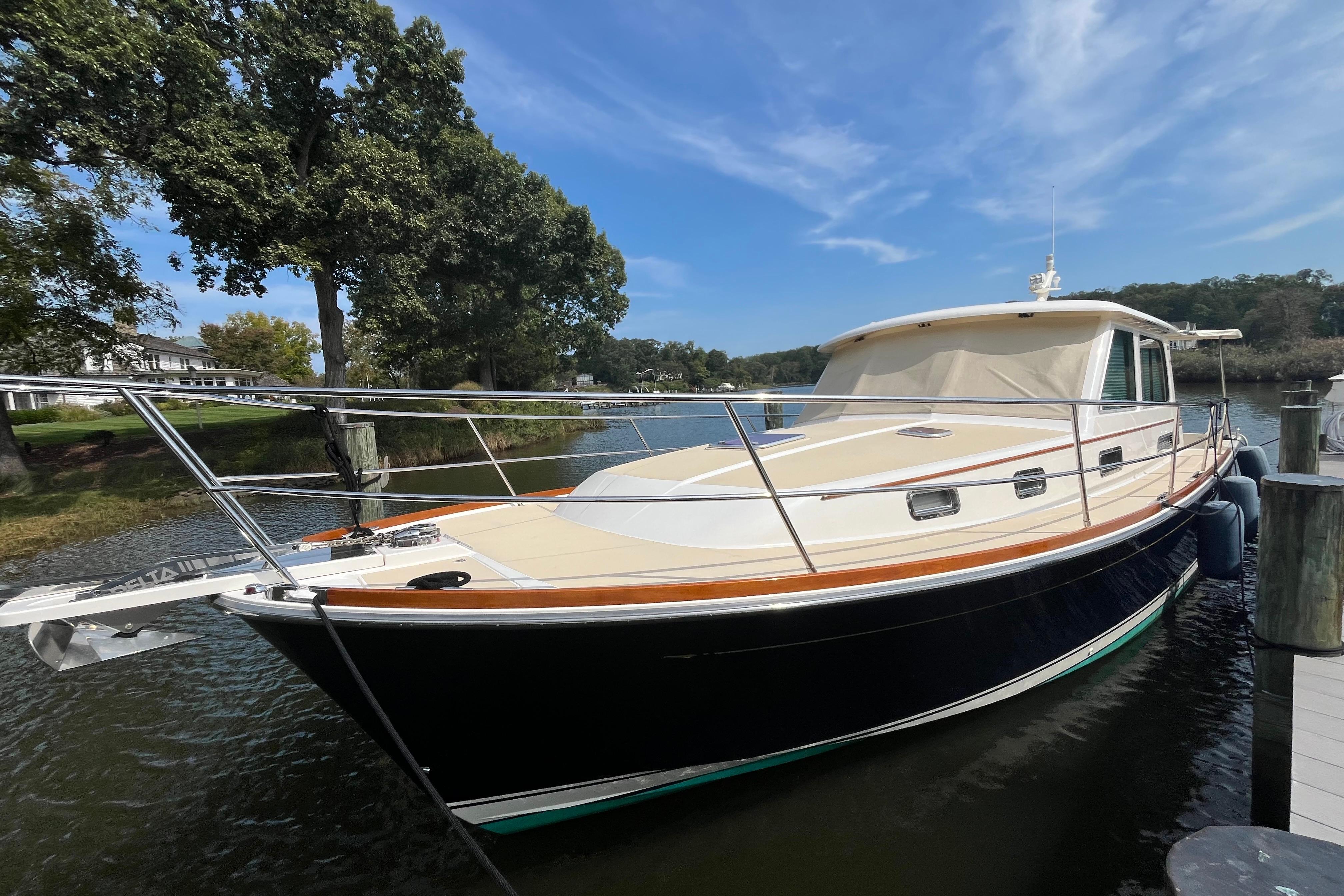 2012 Sabre 42 Salon Express yacht docked by a scenic waterfront.