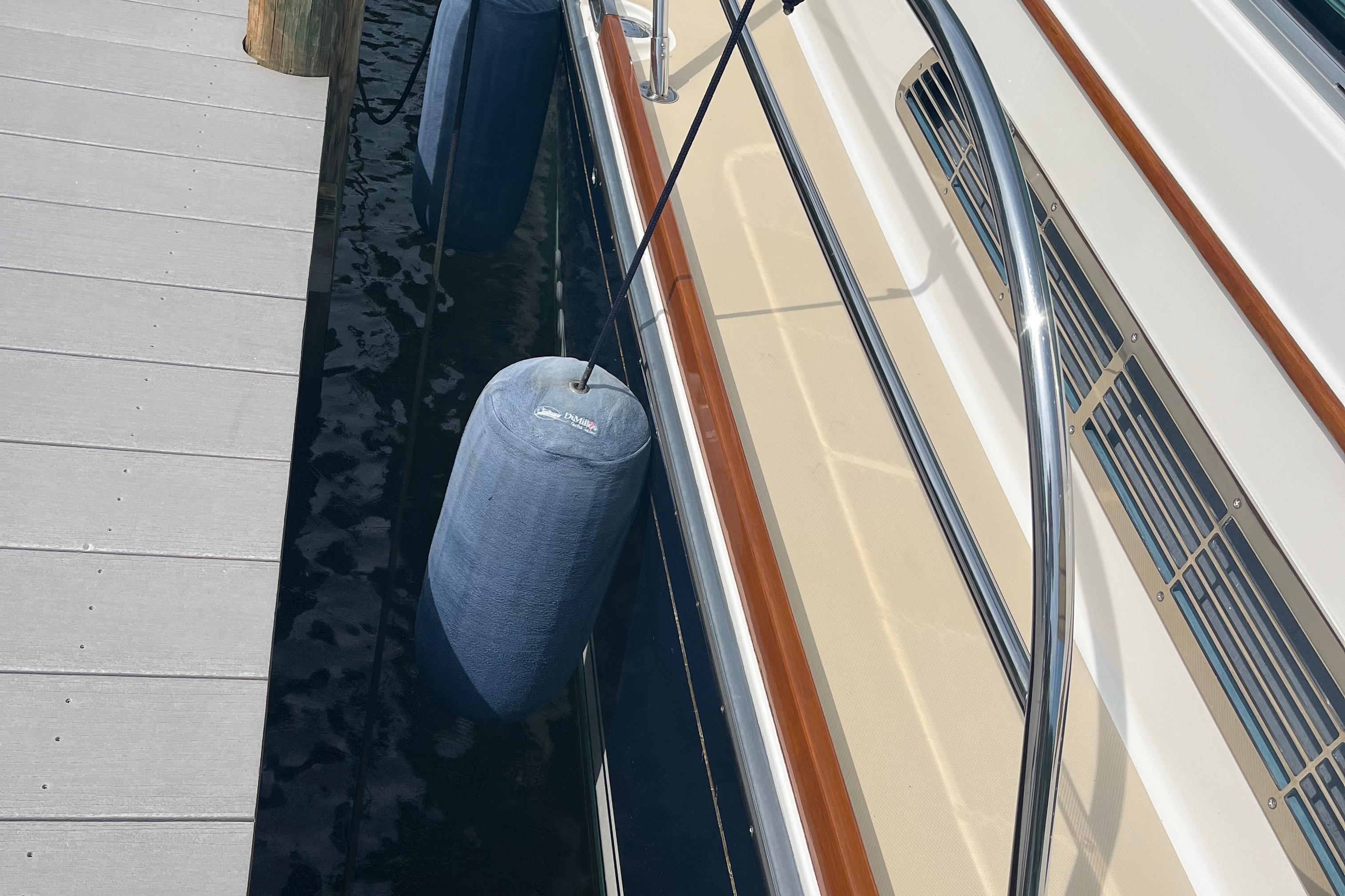 2012 Sabre 42 Salon Express docked with fenders, showcasing sleek design and polished railings.