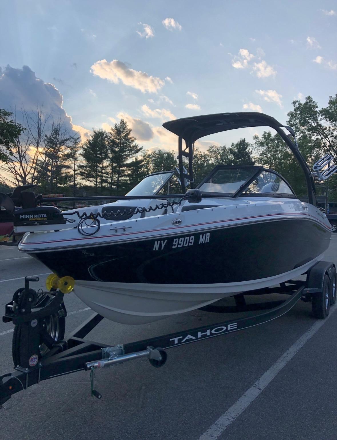 2021 Tahoe 550 TF boat on trailer at sunset, parked in a scenic area.