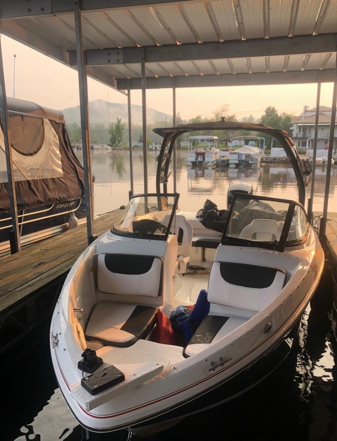 2021 Tahoe 550 TF boat docked at a marina with scenic lake view.