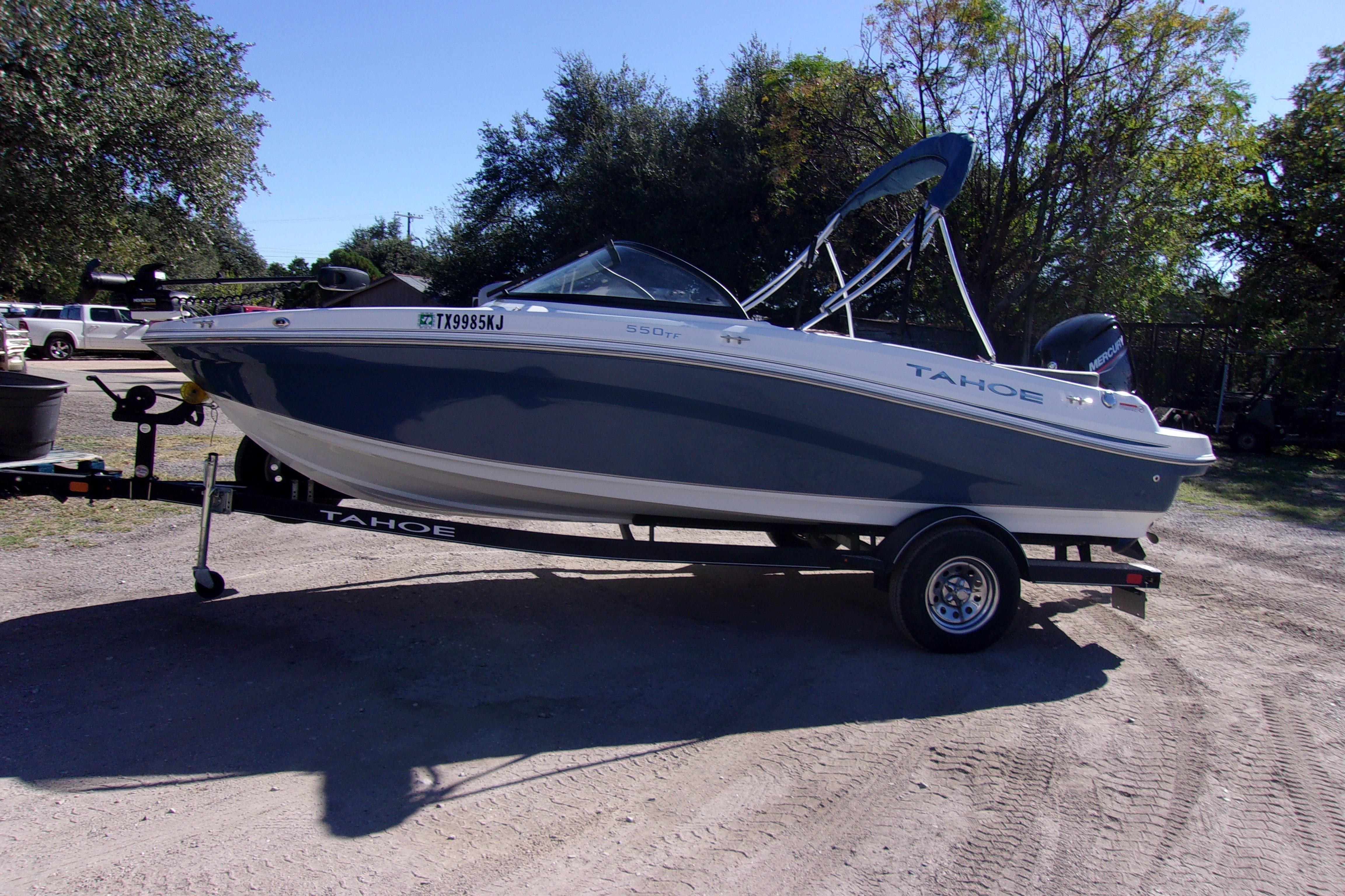 2021 Tahoe 550 TF boat on trailer, parked outdoors, side view.