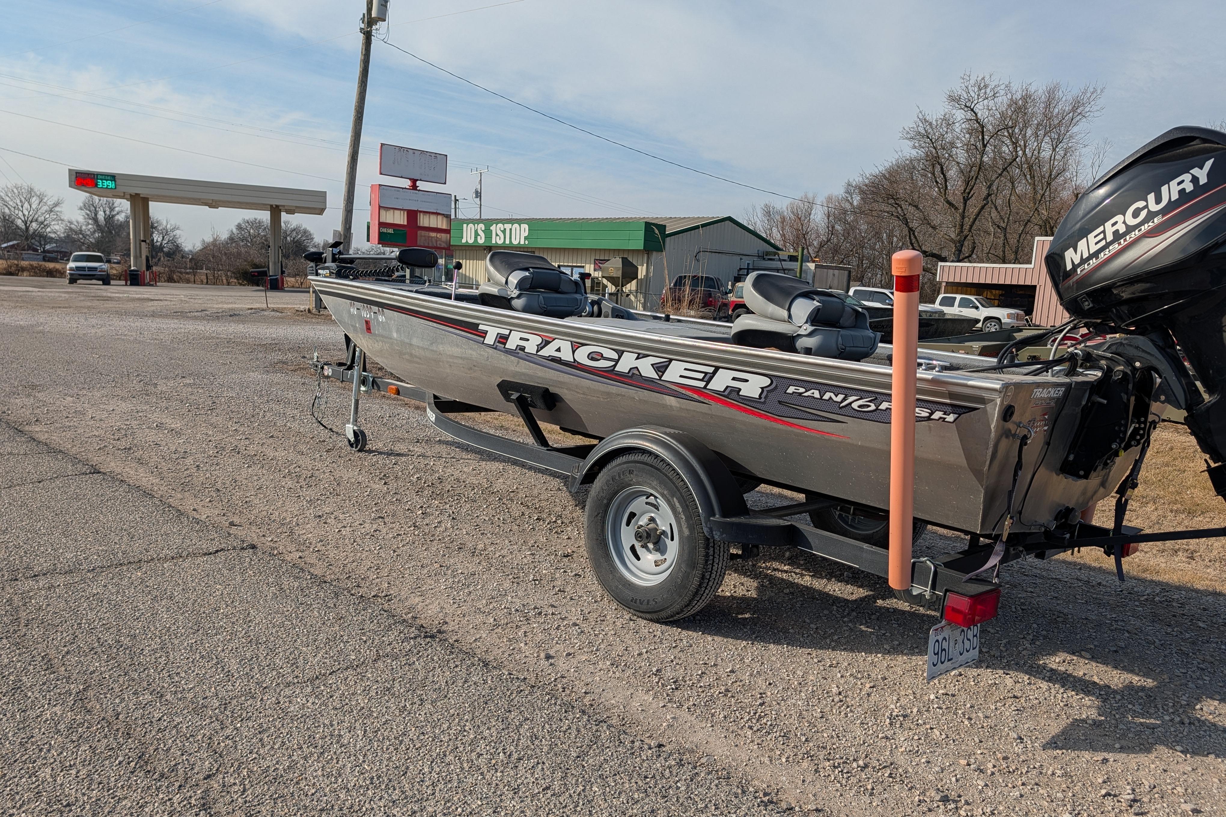 2017 Tracker Panfish 16 boat with Mercury engine parked near a gas station.