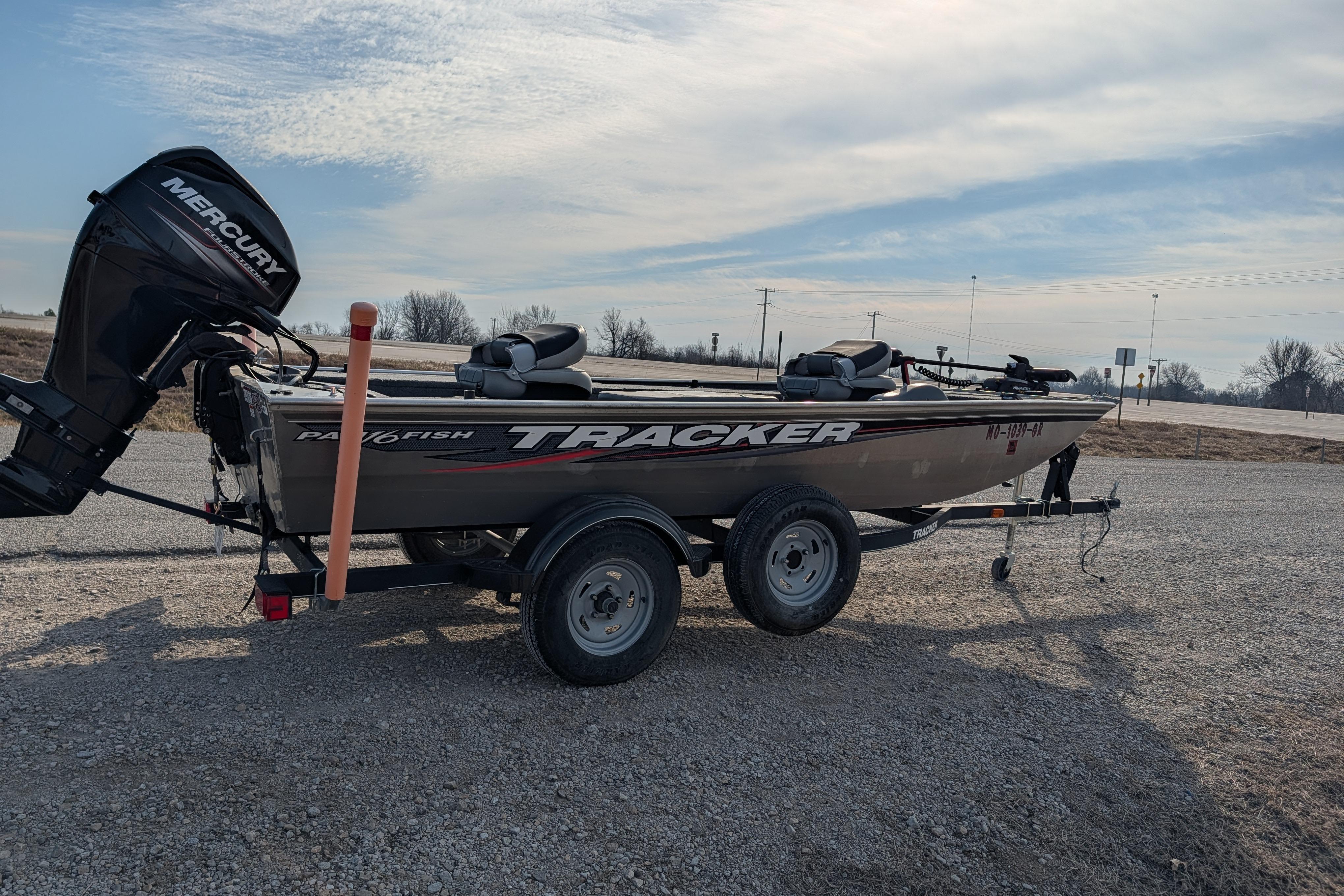 2017 Tracker Panfish 16 boat on trailer with Mercury outboard motor, parked on gravel.