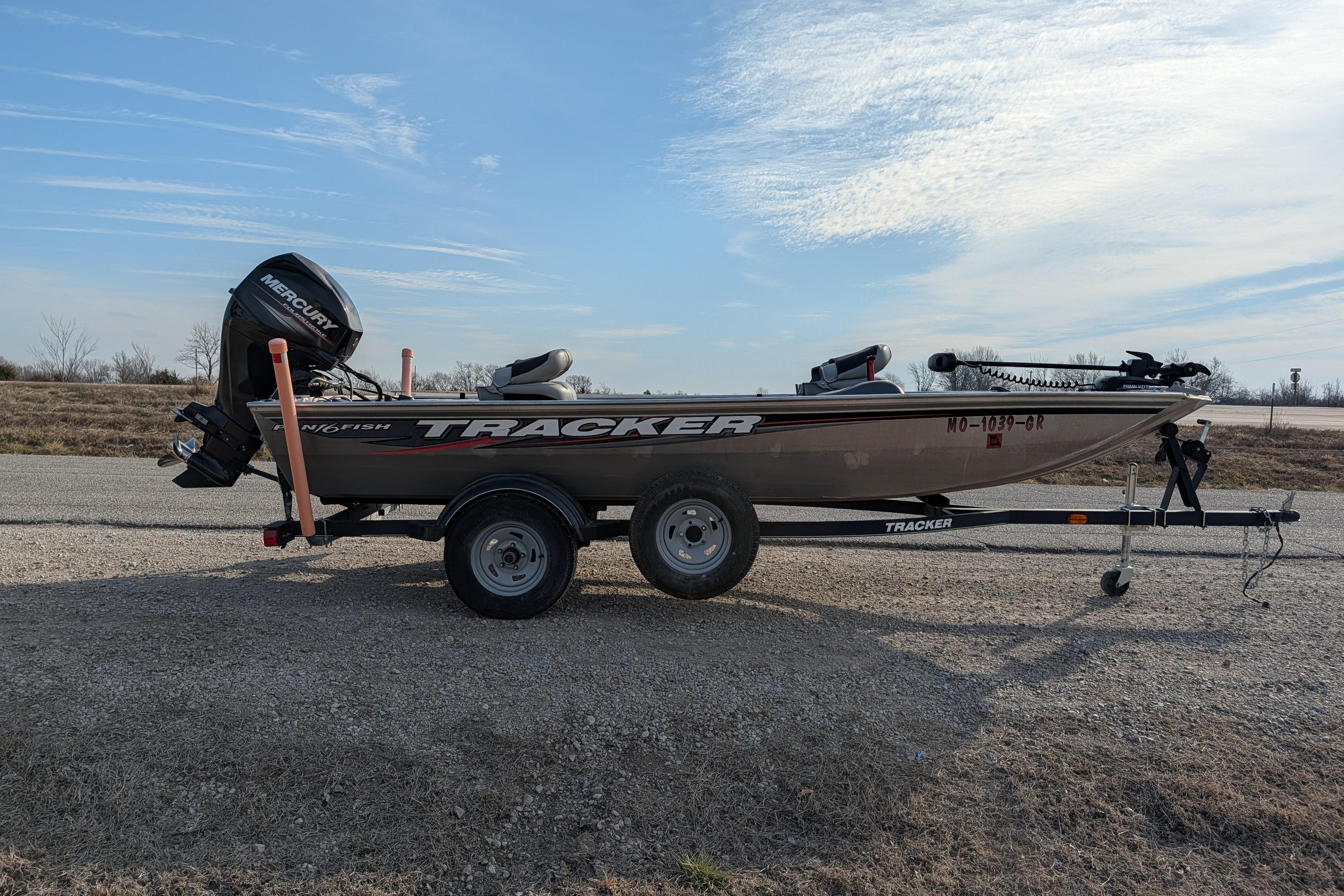 2017 Tracker Panfish 16 boat on trailer, parked on gravel road under clear sky.