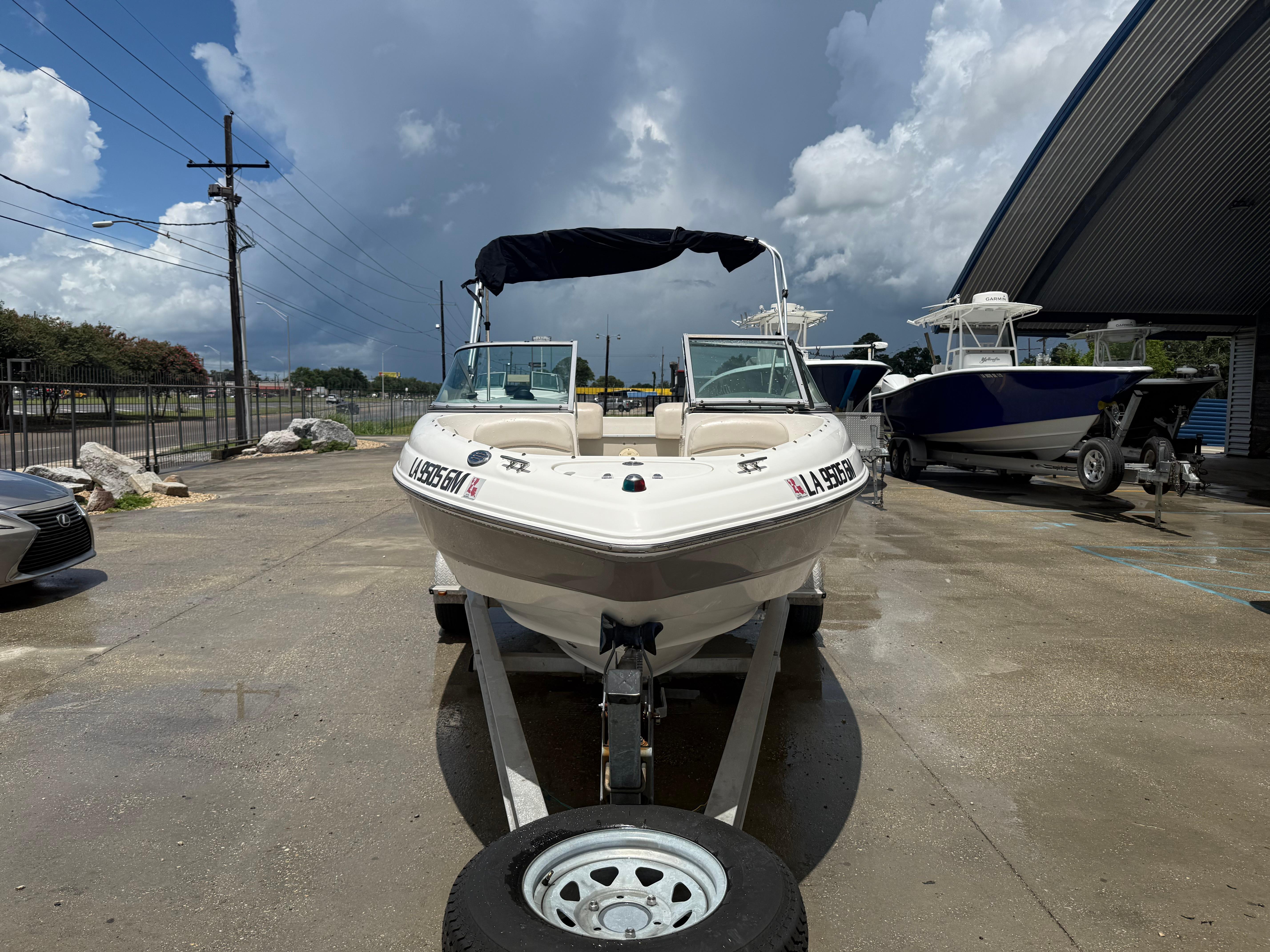 2007 Chaparral 190 SSi boat on trailer, parked outdoors under cloudy sky.