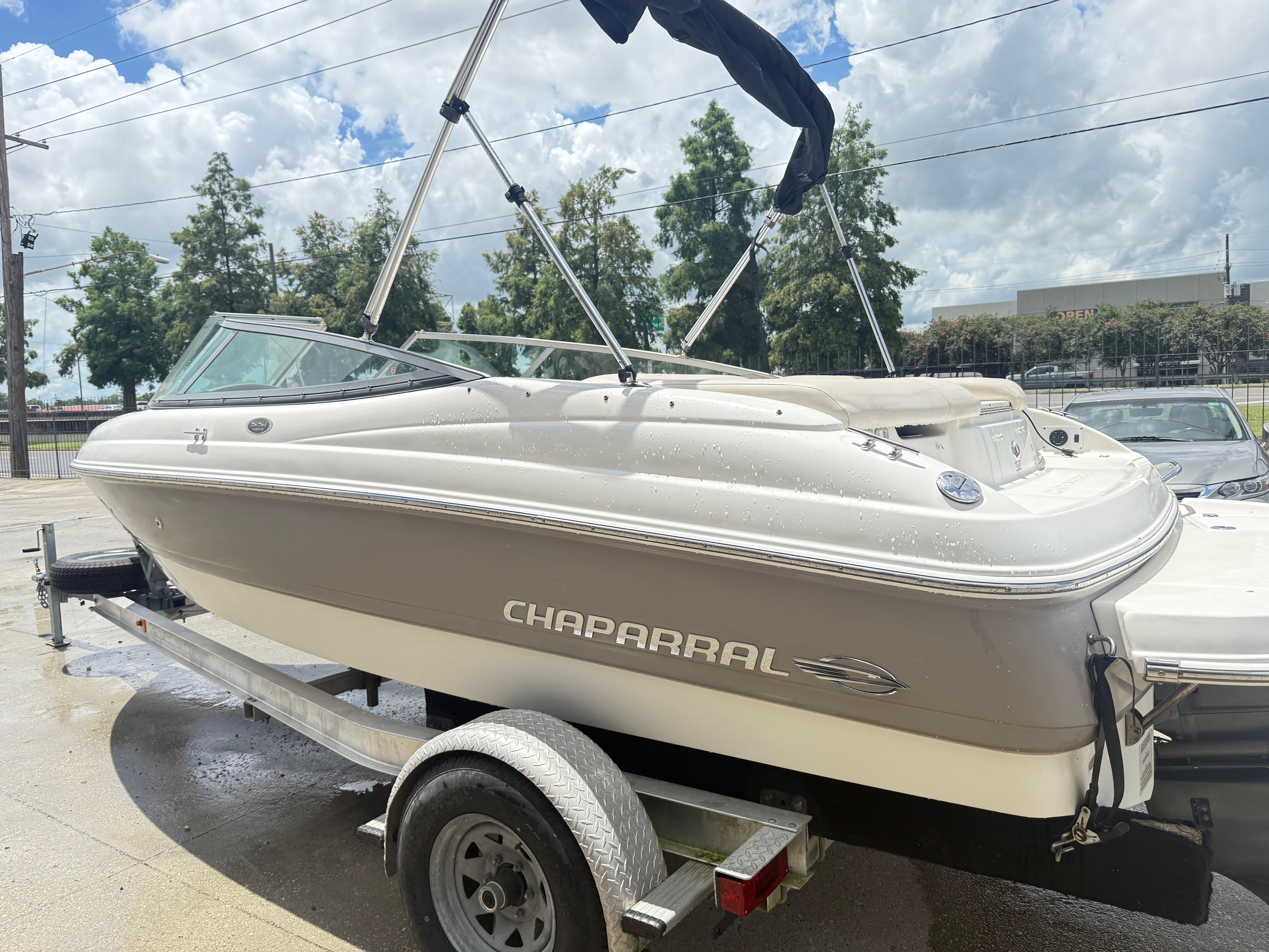 2007 Chaparral 190 SSi boat on trailer, parked outdoors under cloudy sky.