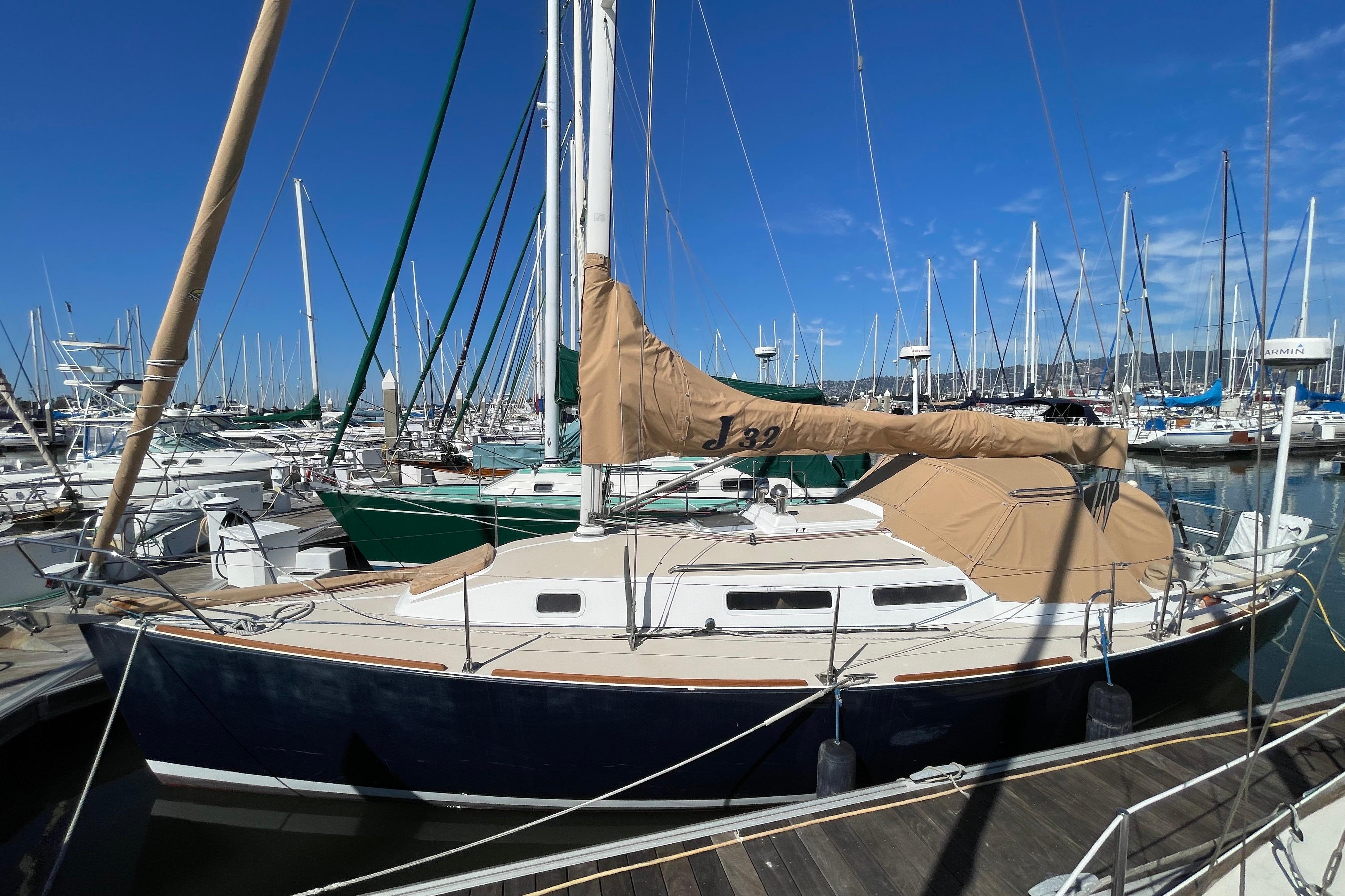 2001 J Boats J/32 sailboat docked in marina under clear blue sky.
