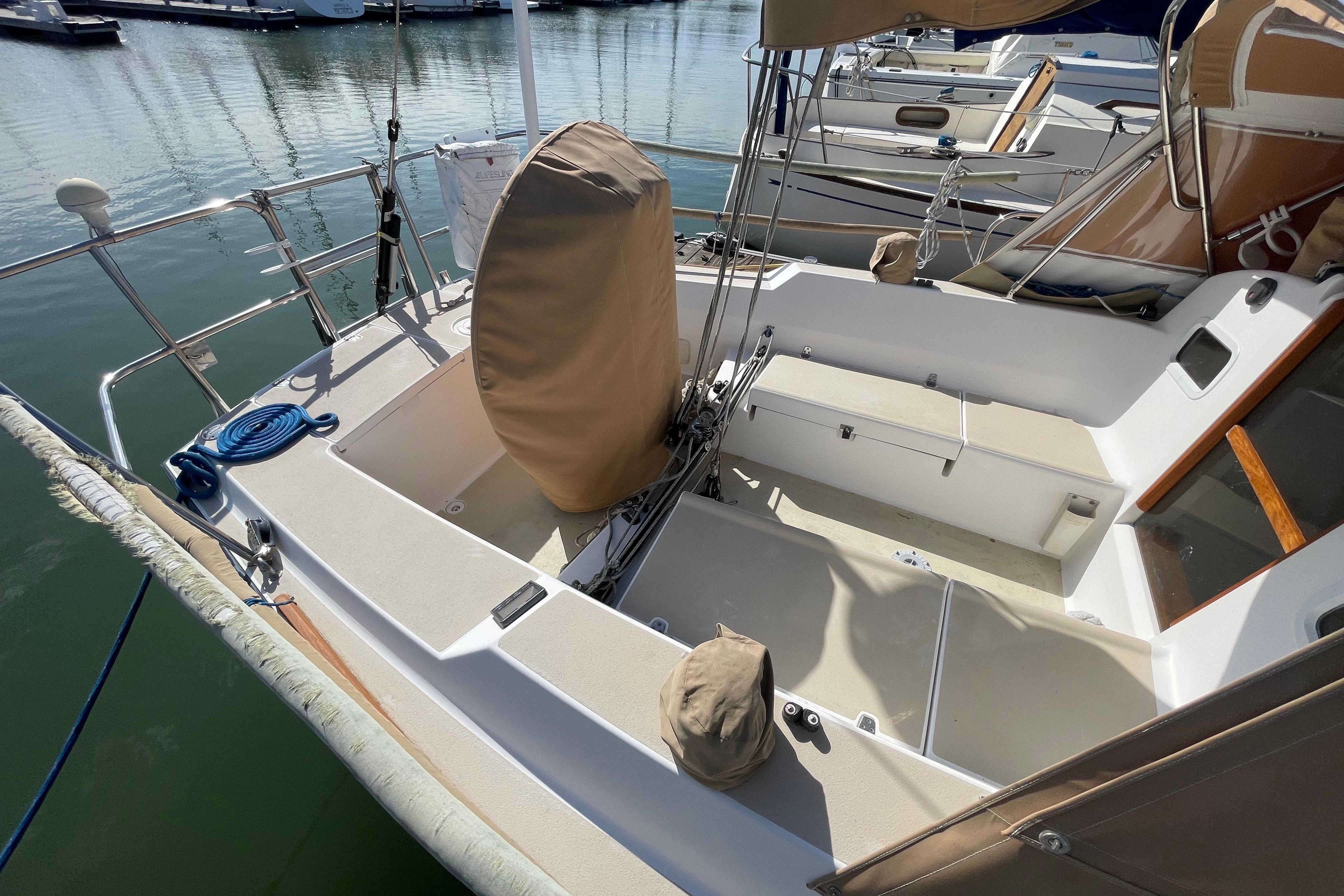 2001 J Boats J/32 sailboat cockpit with covered wheel, docked in marina.