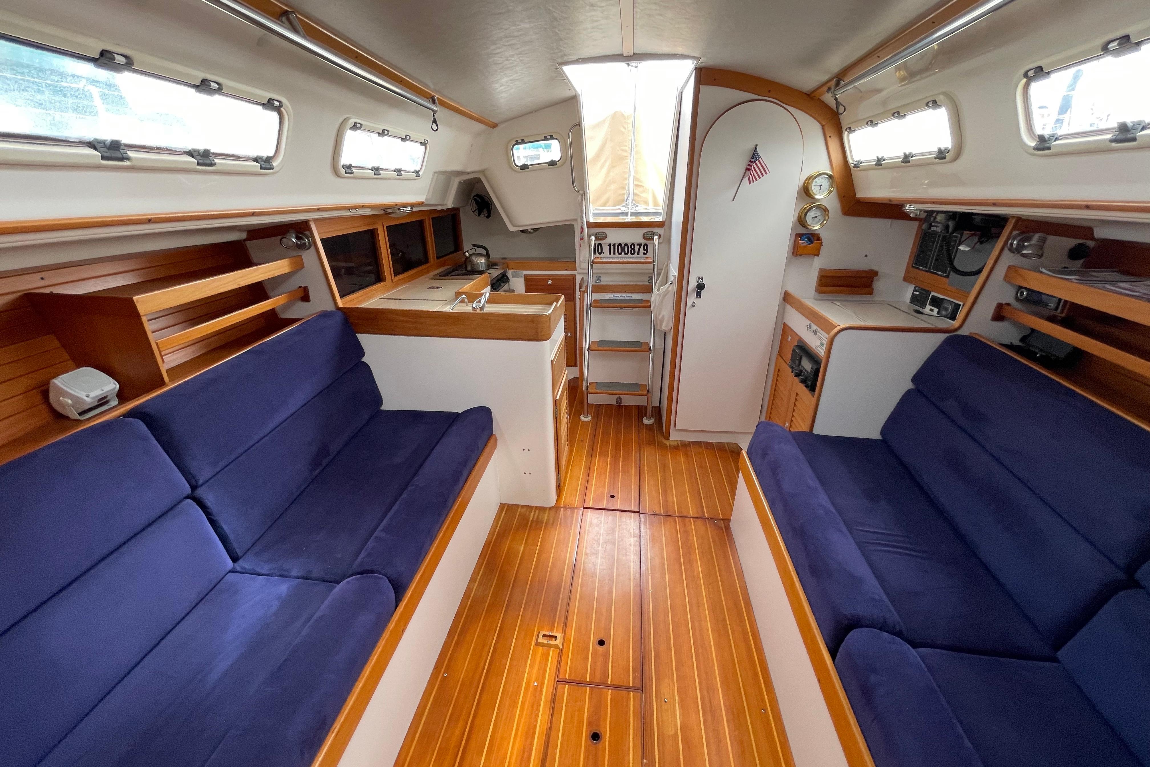 Interior of 2001 J Boats J/32 sailboat with blue seating and wooden flooring.