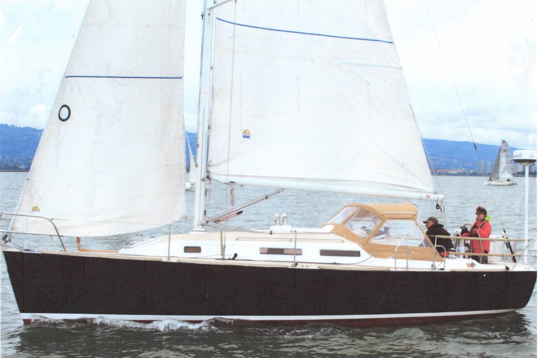 2001 J Boats J/32 sailing on calm waters with crew onboard.