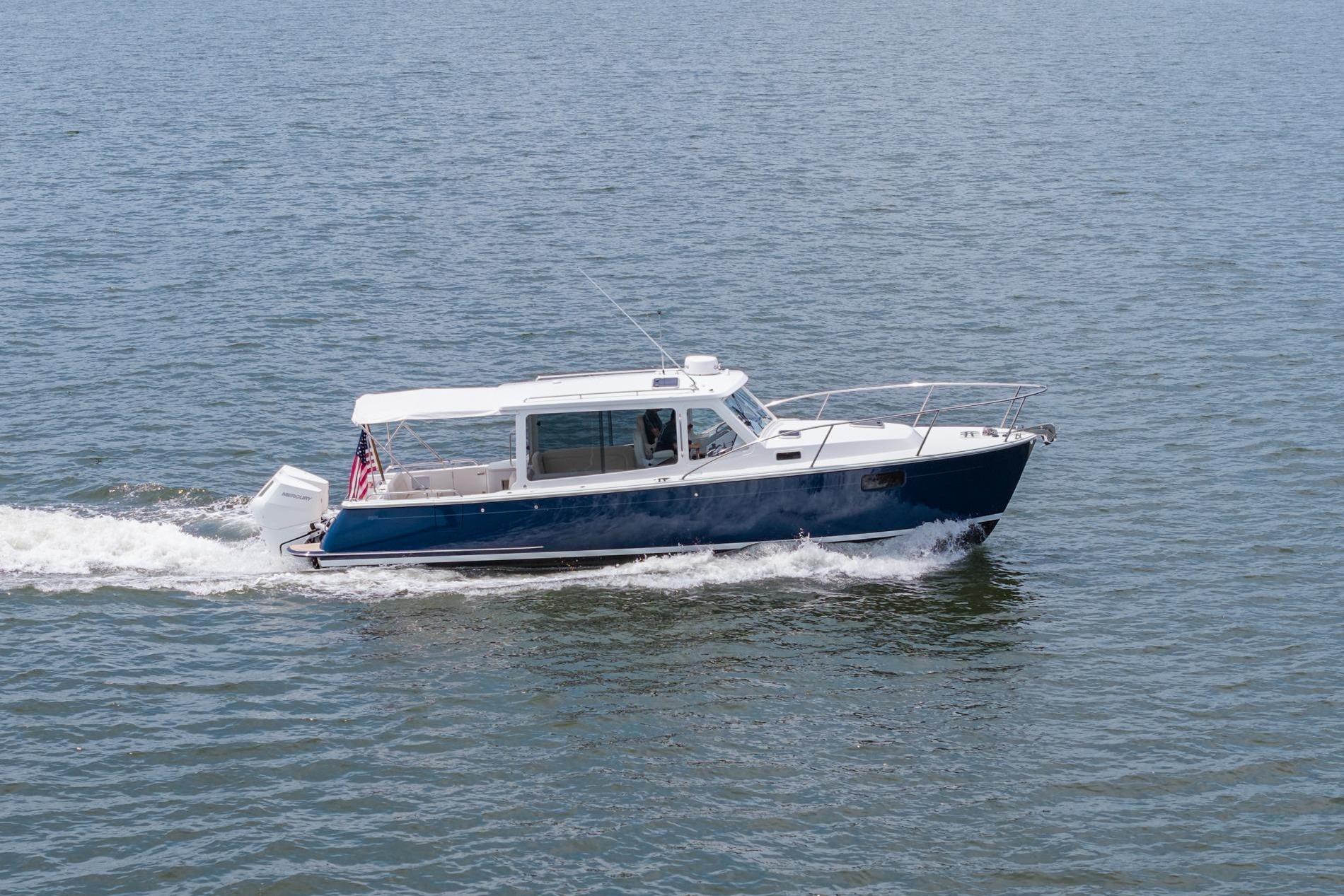 2025 MJM 35 boat cruising on open water, displaying sleek design and American flag.