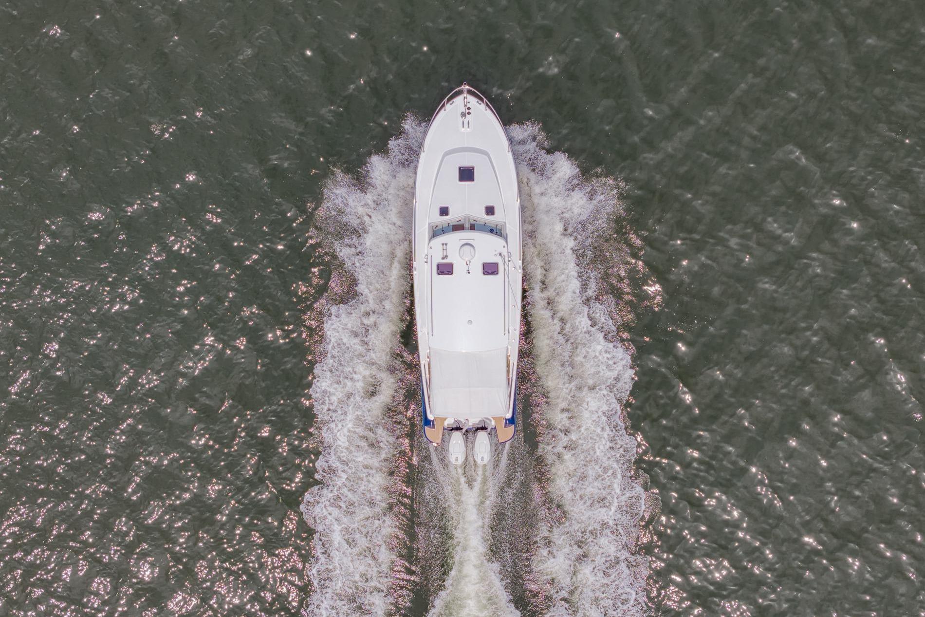 Aerial view of 2025 MJM 35 boat cruising on water, creating a wake.