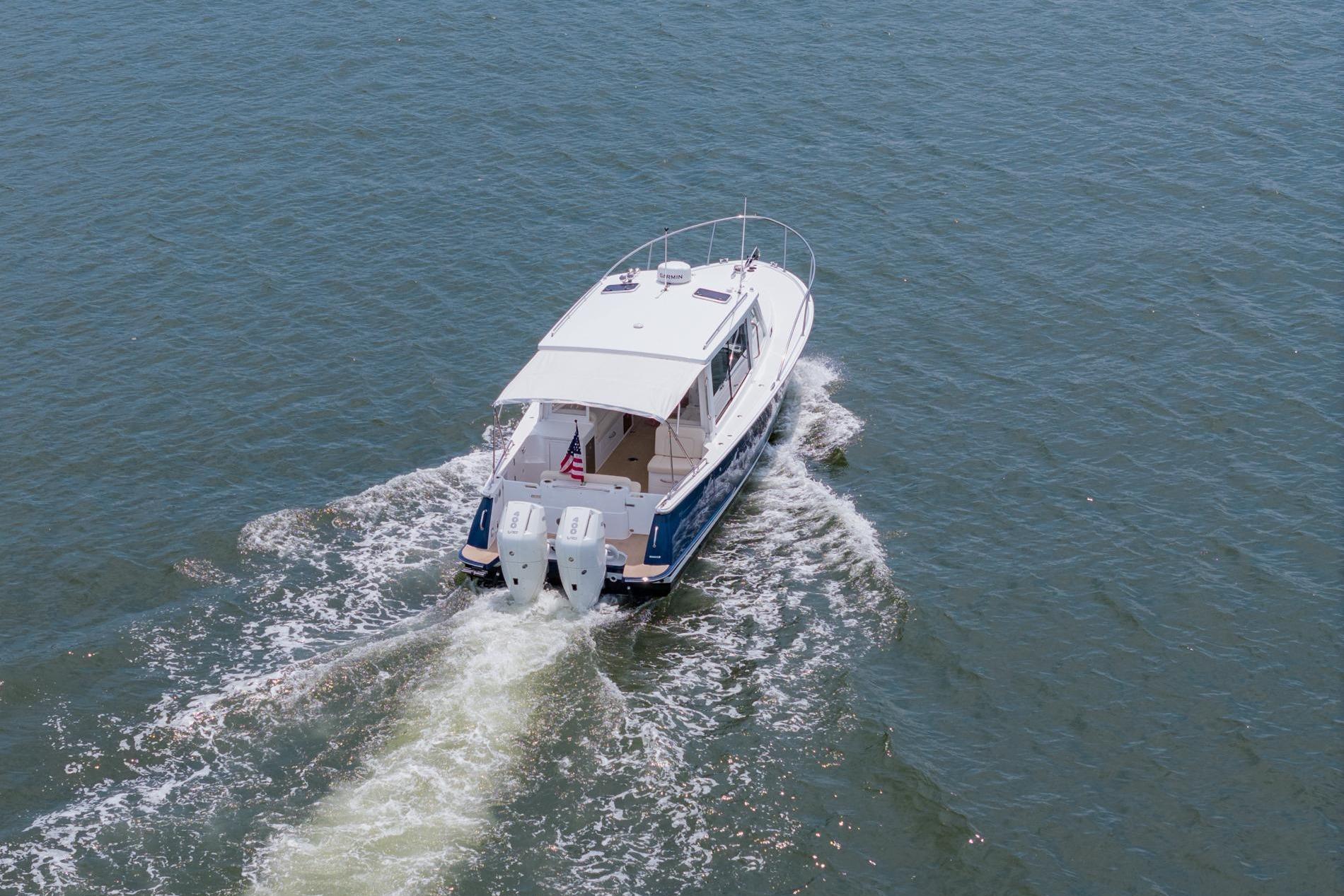 2025 MJM 35 boat cruising on open water, rear view.