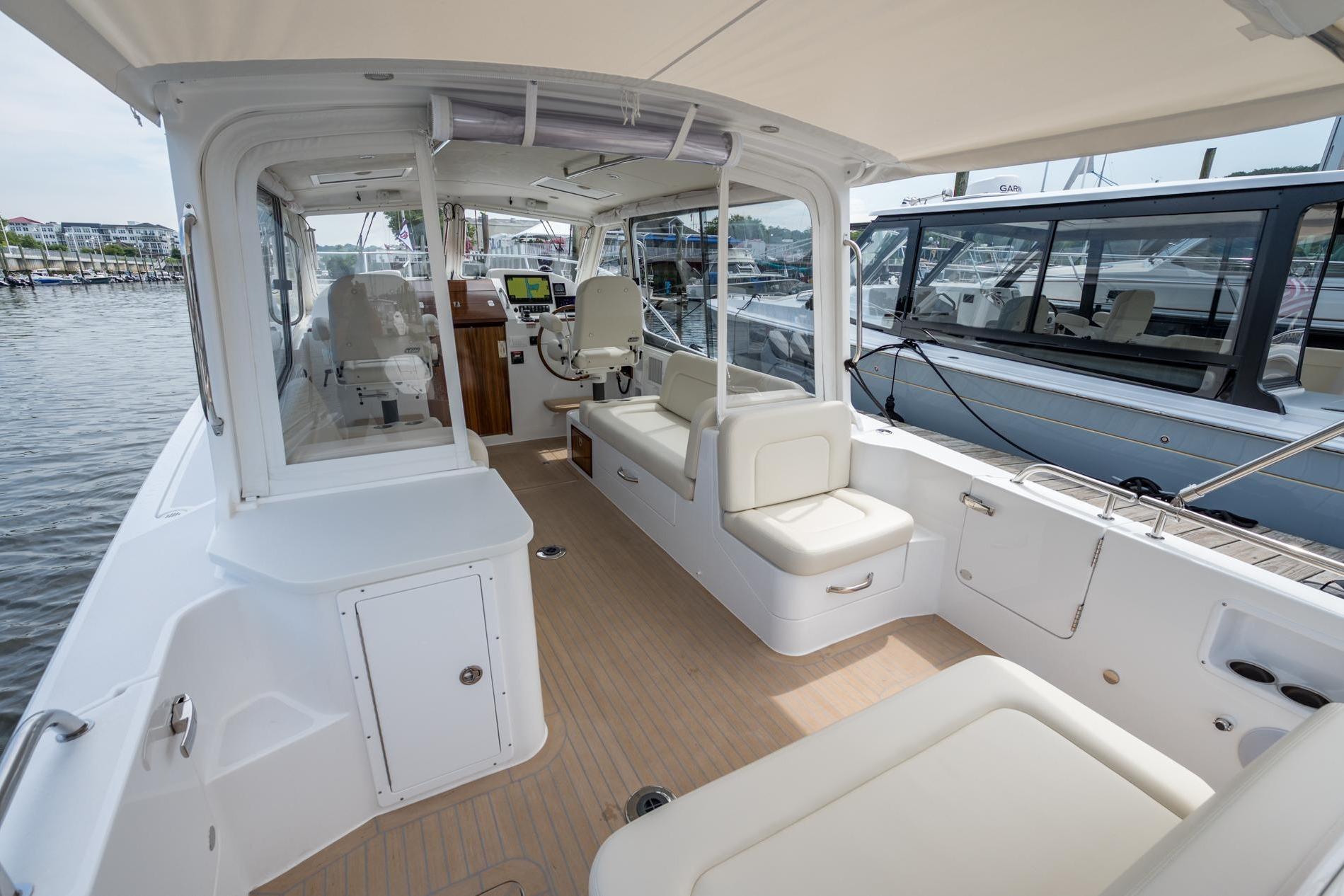 2025 MJM 35 boat interior with seating, helm, and docked at marina.