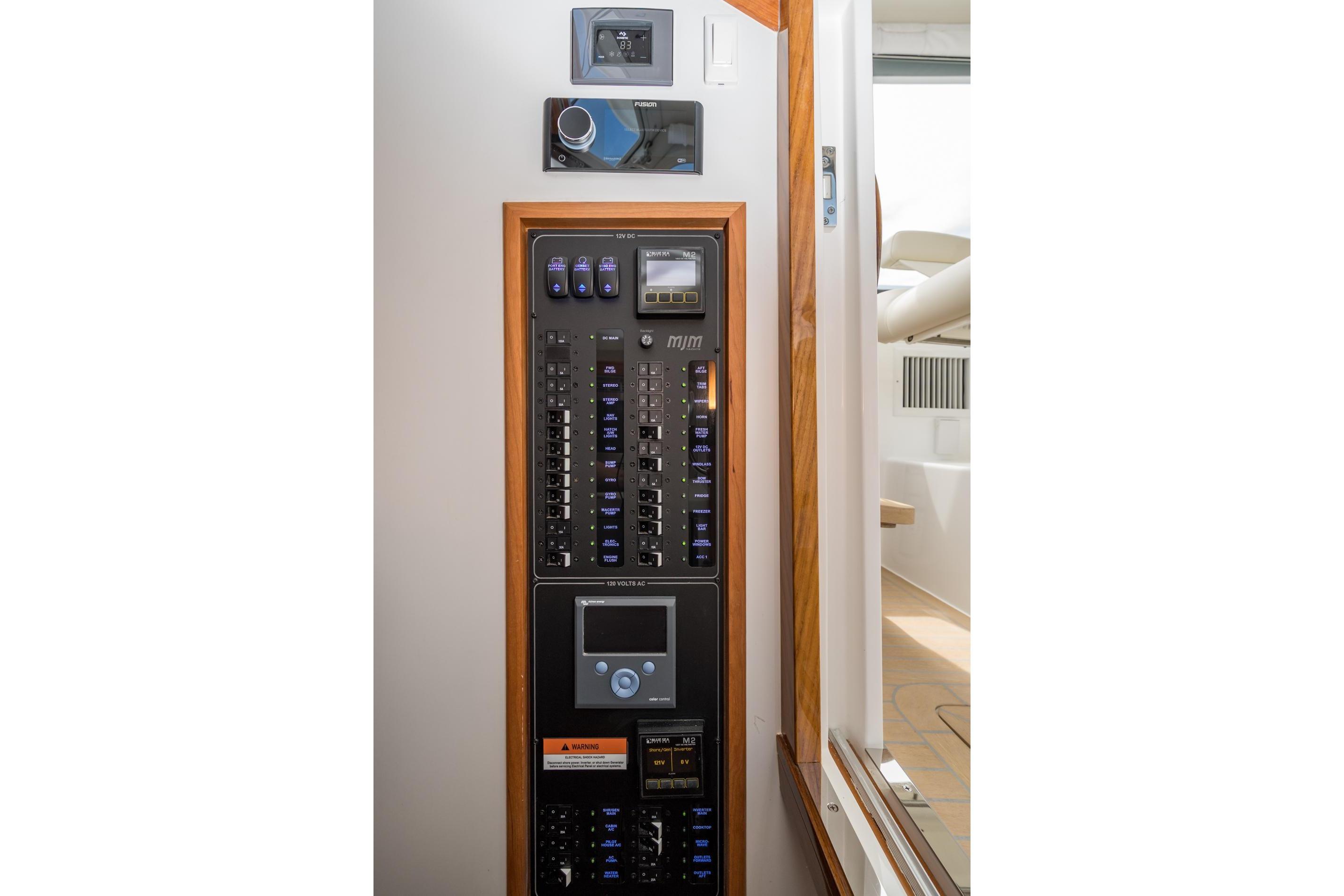 Electrical control panel on 2025 MJM 35 boat, featuring switches and digital displays.