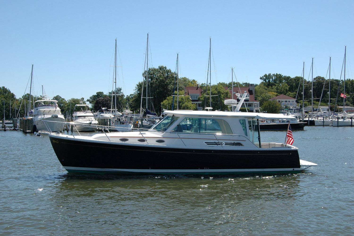 2014 Back Cove 37 yacht docked in a marina with sailboats in the background.