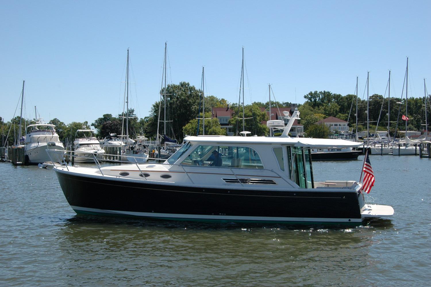 2014 Back Cove 37 yacht docked in a marina, surrounded by sailboats.