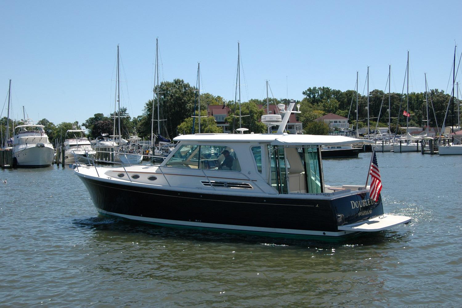 2014 Back Cove 37 boat docked in a marina with sailboats in the background.