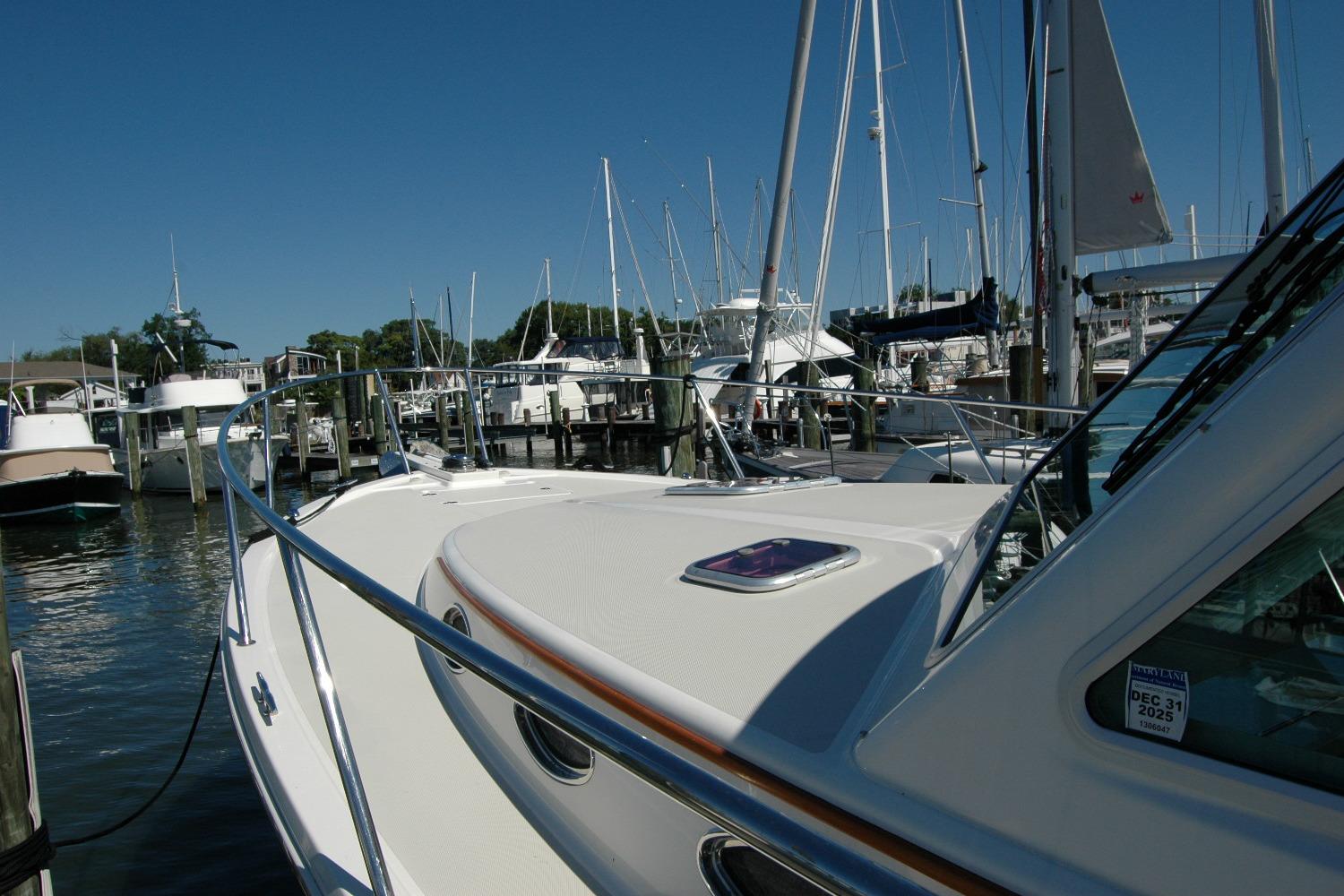 2014 Back Cove 37 yacht docked at a marina, surrounded by sailboats under a clear blue sky.