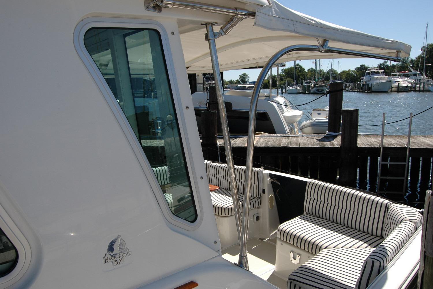 2014 Back Cove 37 yacht with striped seating, docked at a marina.