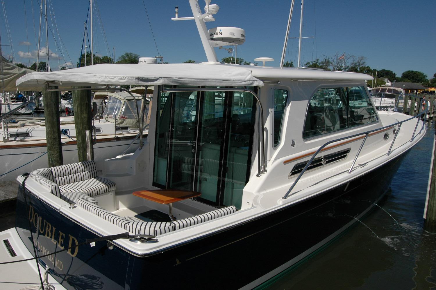 2014 Back Cove 37 yacht docked, featuring sleek design and spacious seating area.