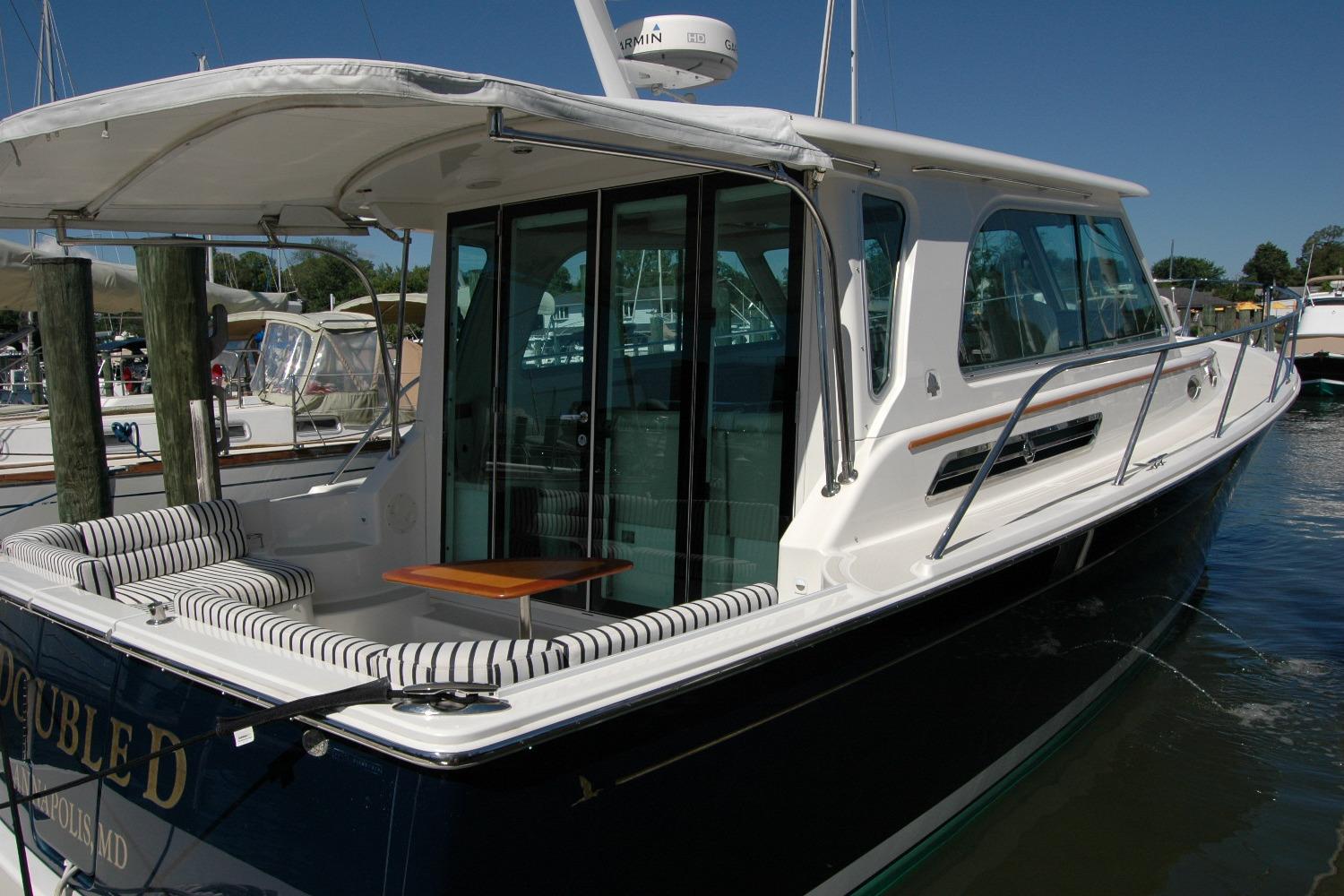 2014 Back Cove 37 yacht docked, featuring sleek design and comfortable seating area.