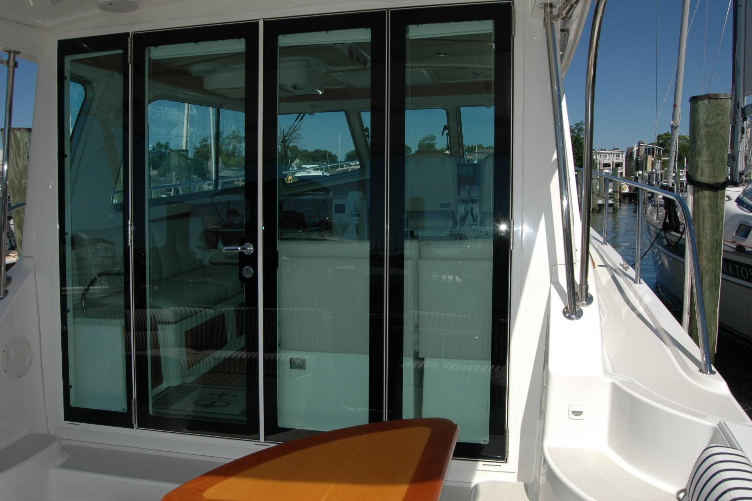 2014 Back Cove 37 yacht with glass doors, docked at a marina.