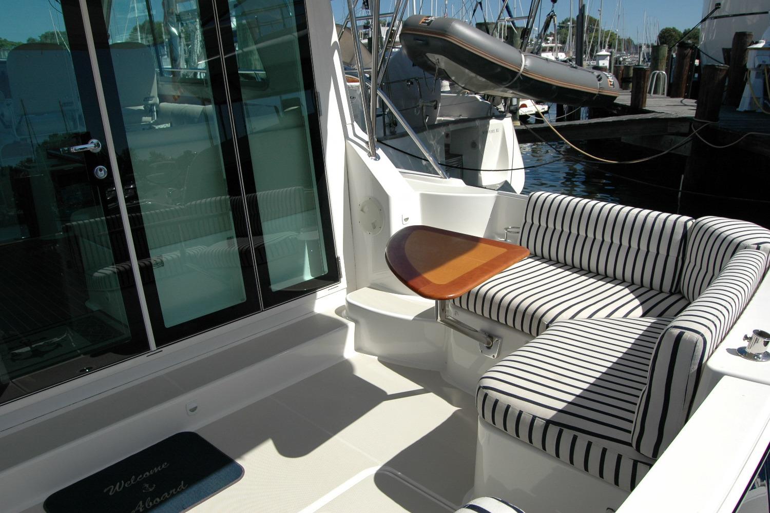 2014 Back Cove 37 yacht with striped seating and wooden table on deck.