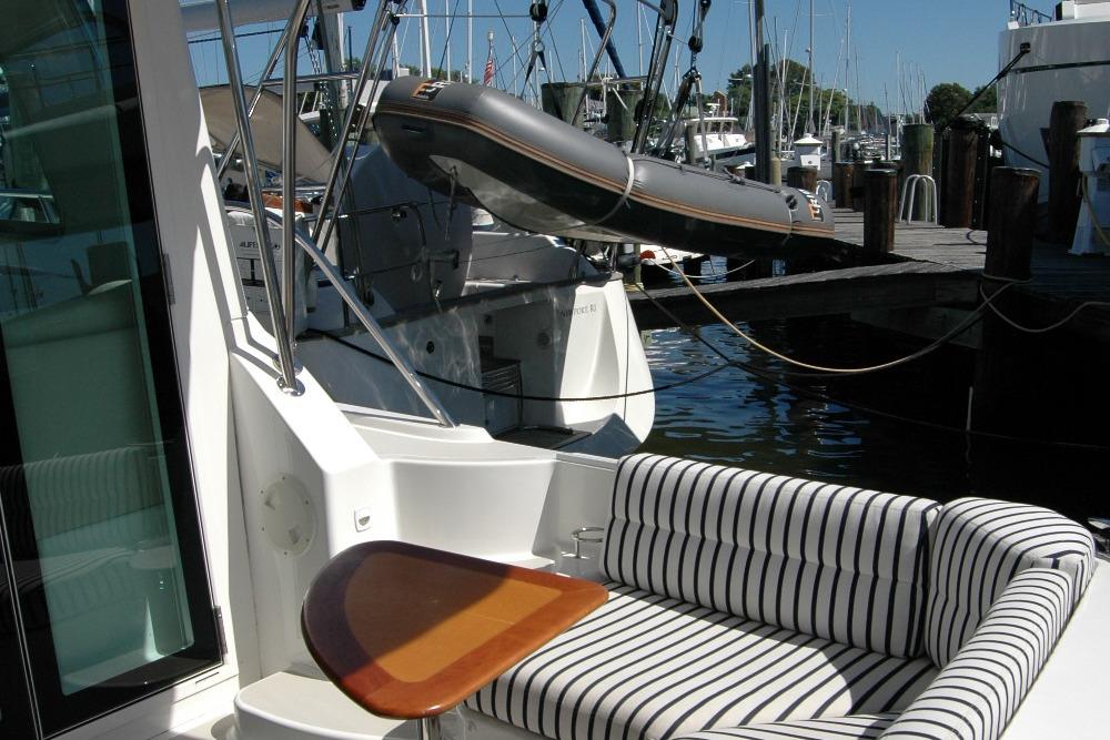 2014 Back Cove 37 yacht with striped seating and docked inflatable boat.