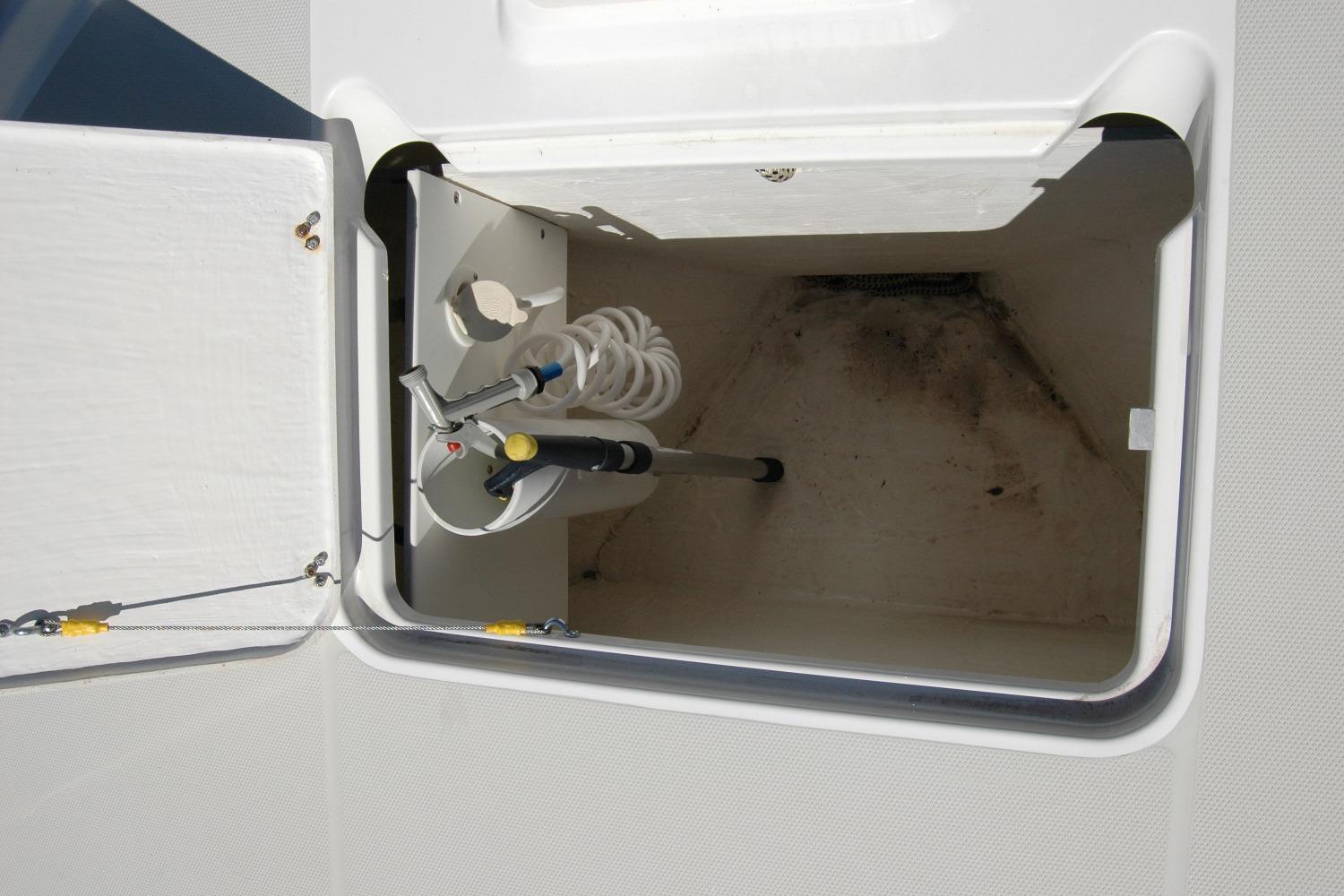 Storage compartment with hose and nozzle on a 2014 Back Cove 37 boat.