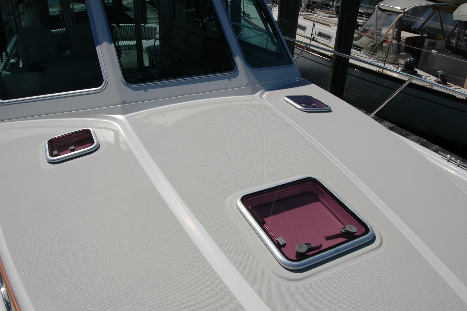 2014 Back Cove 37 boat deck with purple hatches, docked at marina.