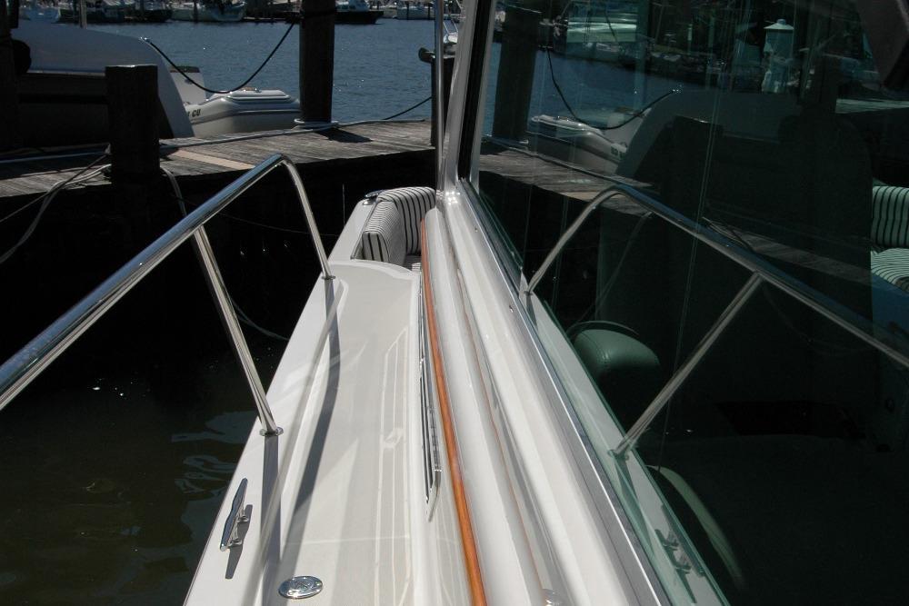 2014 Back Cove 37 yacht docked, showcasing sleek railing and reflective windows.
