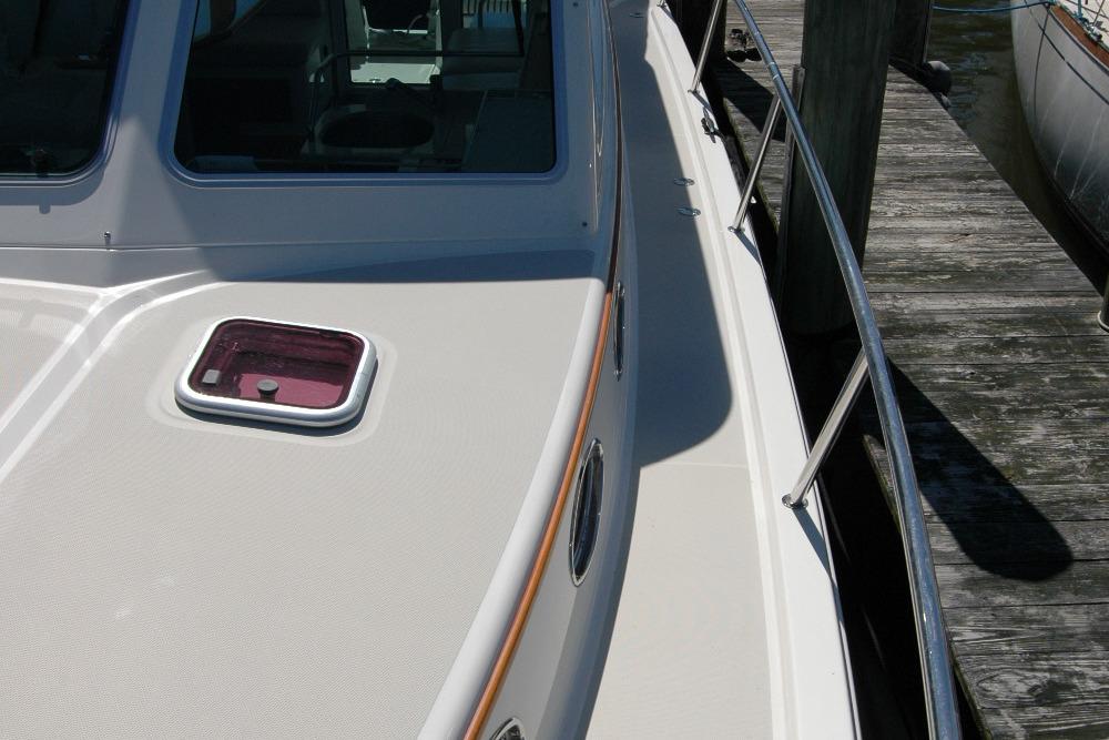 2014 Back Cove 37 boat deck with railing and hatch, docked at a wooden pier.