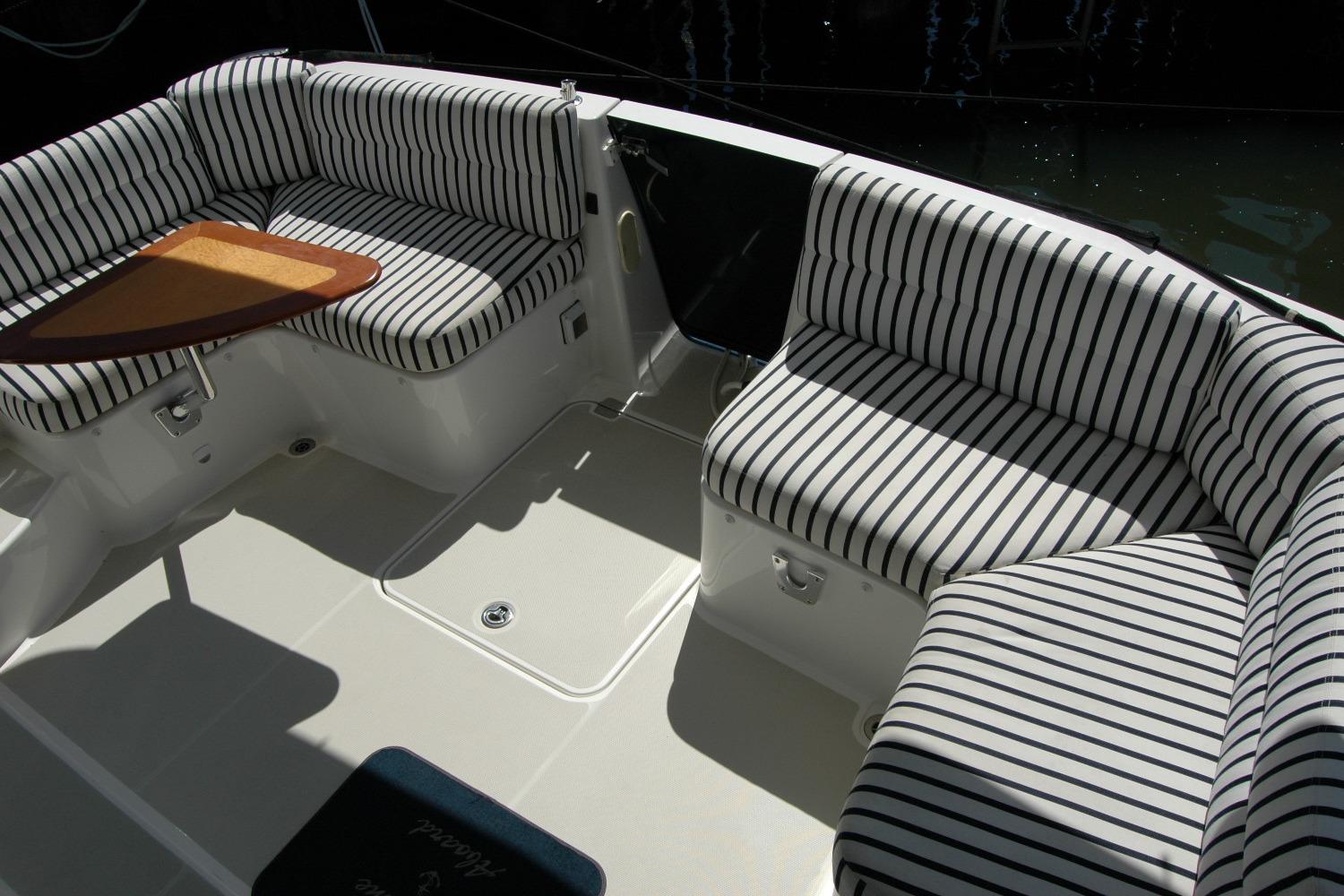 2014 Back Cove 37 boat interior with striped seating and wooden table.