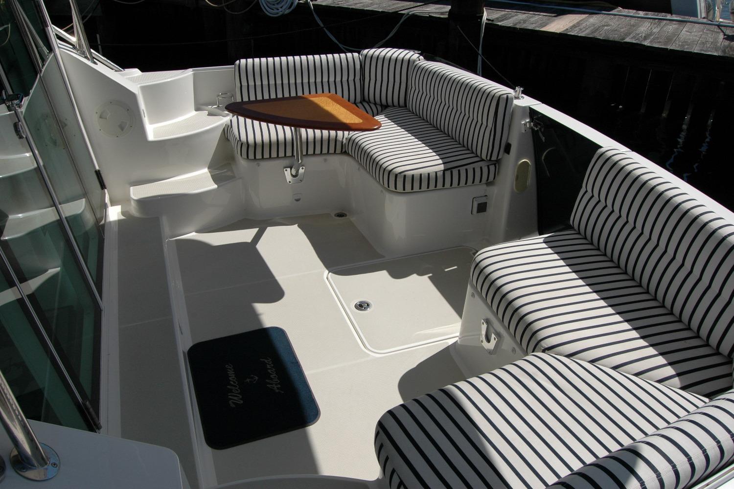 2014 Back Cove 37 boat interior with striped seating and a small wooden table.