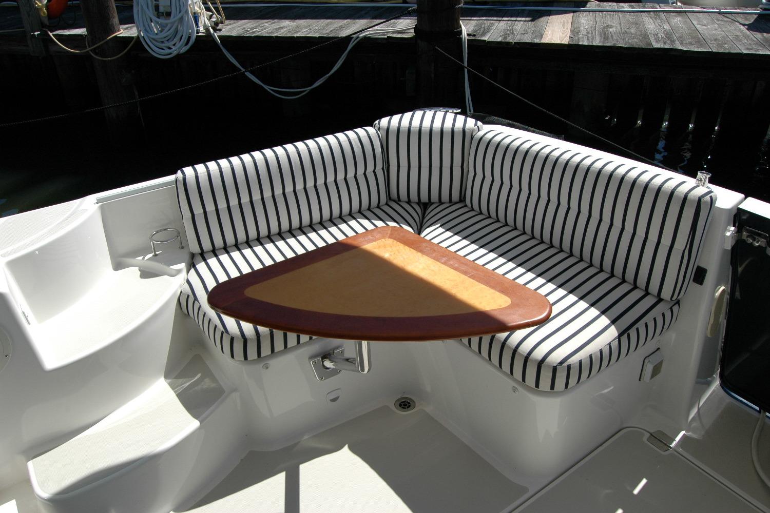 2014 Back Cove 37 boat with striped seating and triangular table in cockpit area.