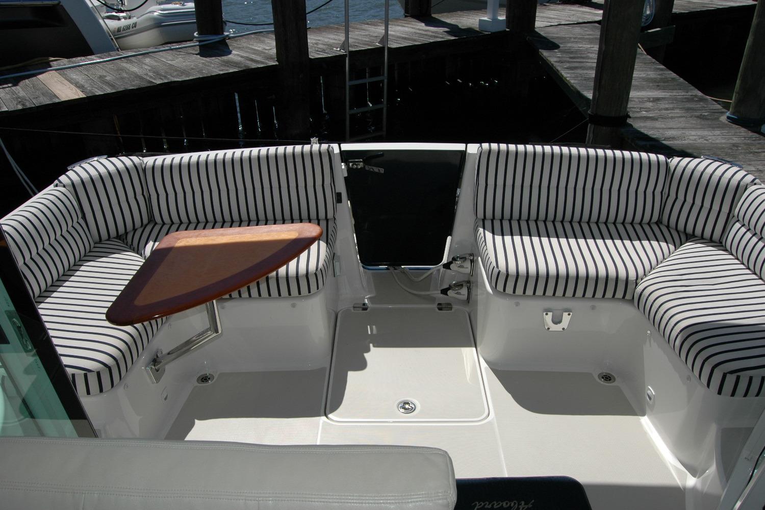 2014 Back Cove 37 boat cockpit with striped seating and wooden table.