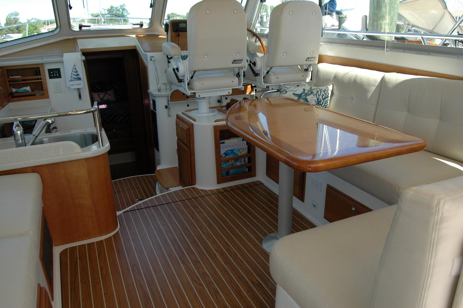 Interior of 2014 Back Cove 37 yacht with seating, table, and helm chairs.