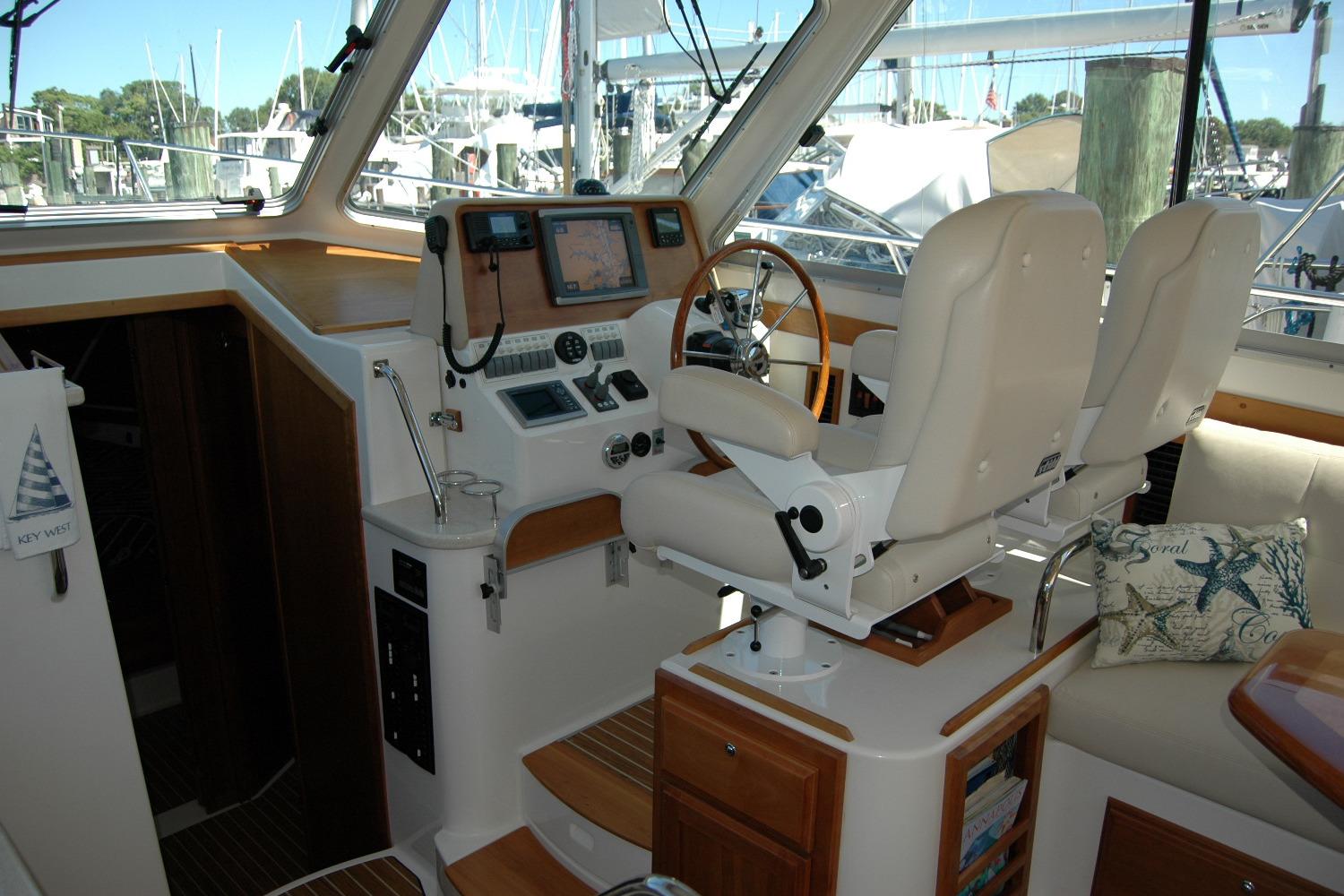 Interior of 2014 Back Cove 37 yacht with helm station and plush seating.