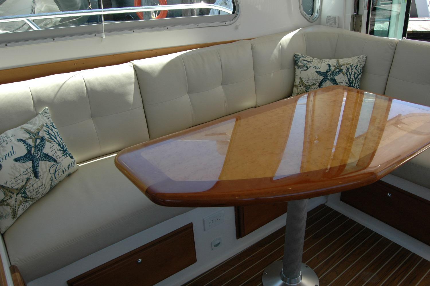 Luxurious interior of 2014 Back Cove 37 yacht with cushioned seating and elegant wooden table.