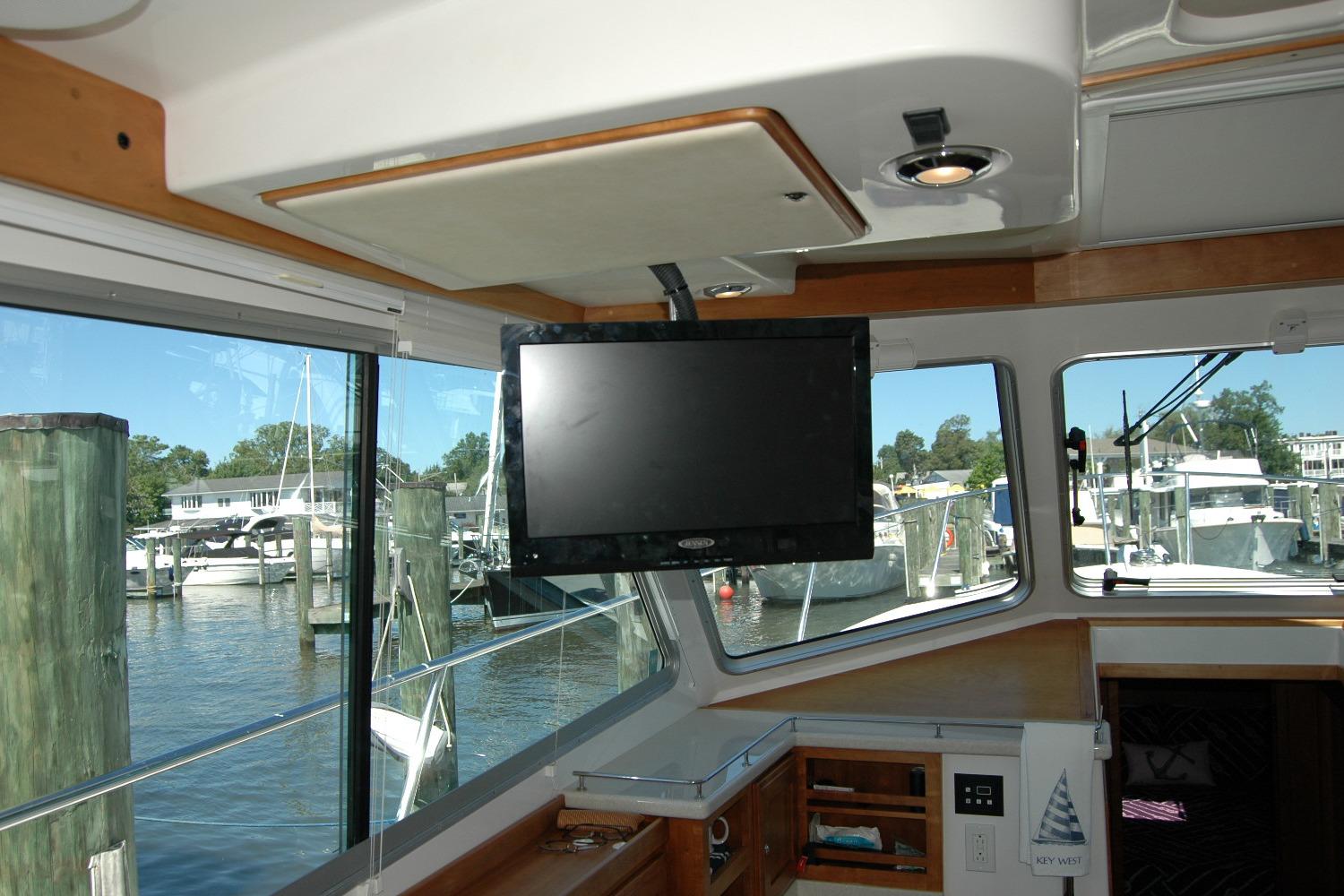 Interior of 2014 Back Cove 37 yacht with TV and marina view.